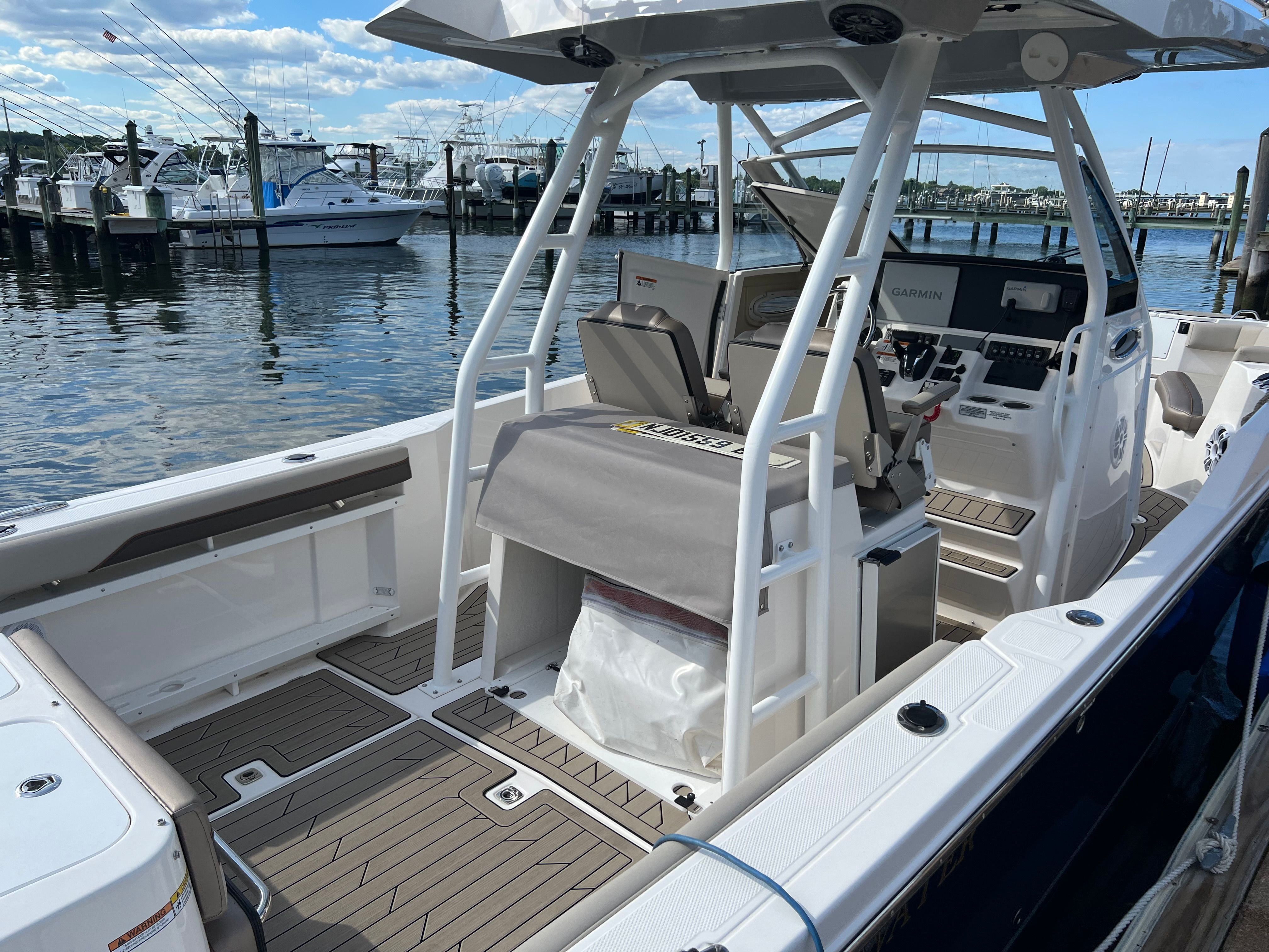 A 2022 Cutwater C-24 CW boat docked. It features a modern cockpit and helm console.