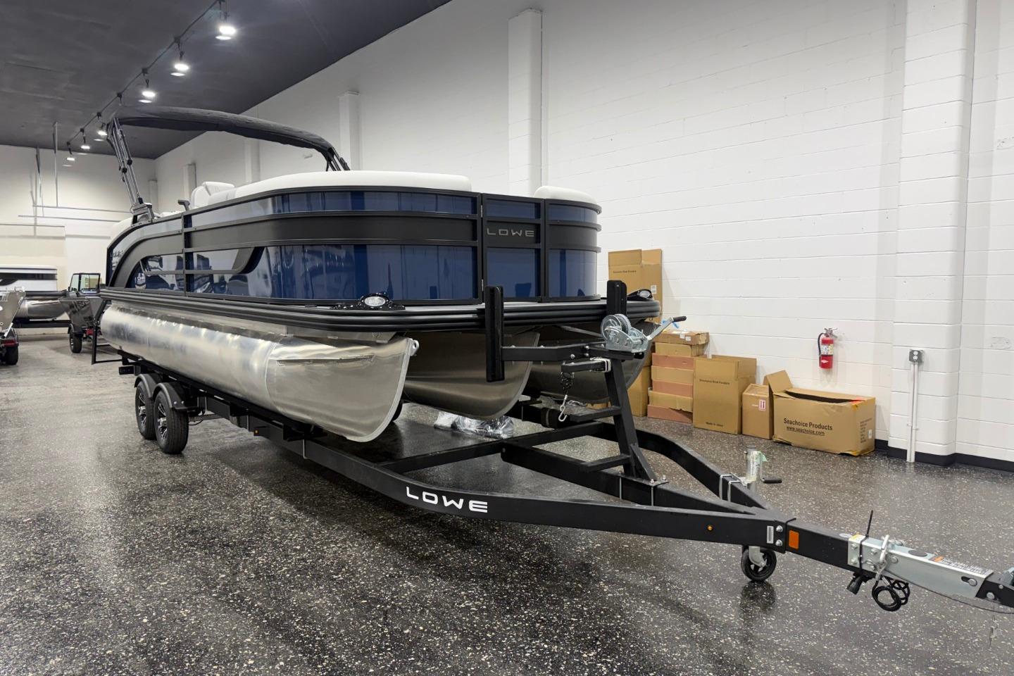 2026 Lowe SS 230 WT pontoon boat on trailer in showroom setting.