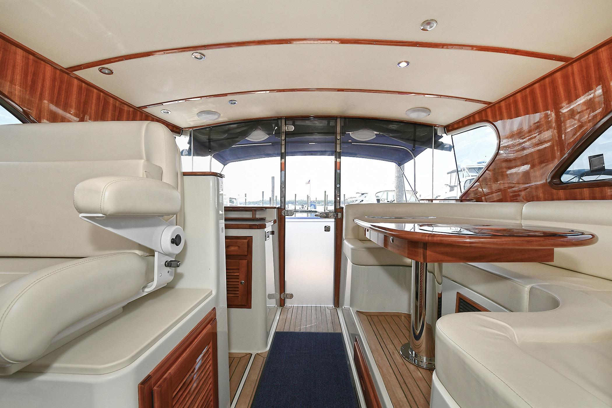 Luxurious interior of 2005 San Juan Downeast Express yacht with elegant wood and leather finishes.
