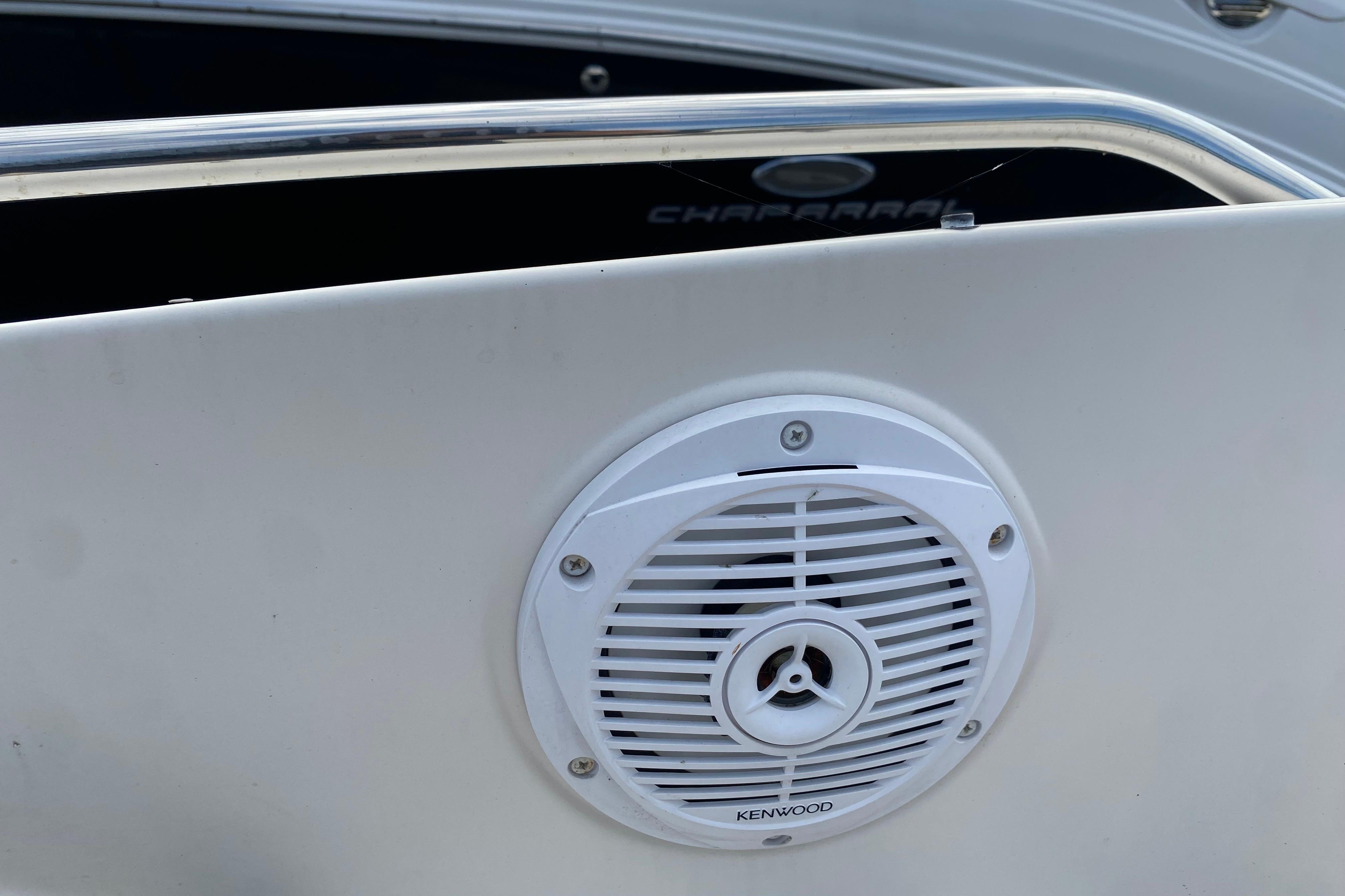 White Kenwood speaker on a 2007 Monterey 234FSX boat, featuring a sleek metal railing.