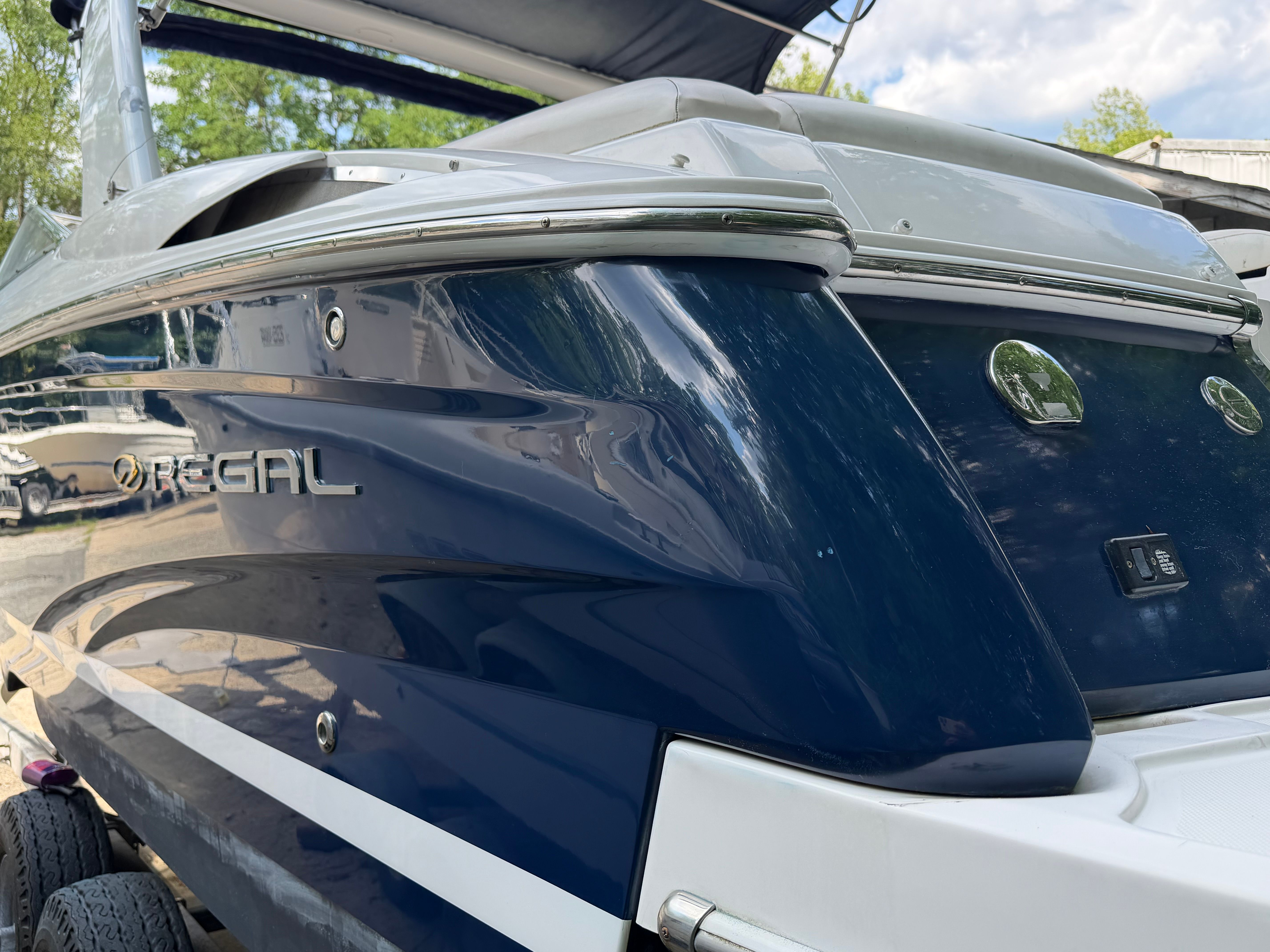 A 2011 Regal 2750 Cuddy boat with a glossy blue hull and silver accents.