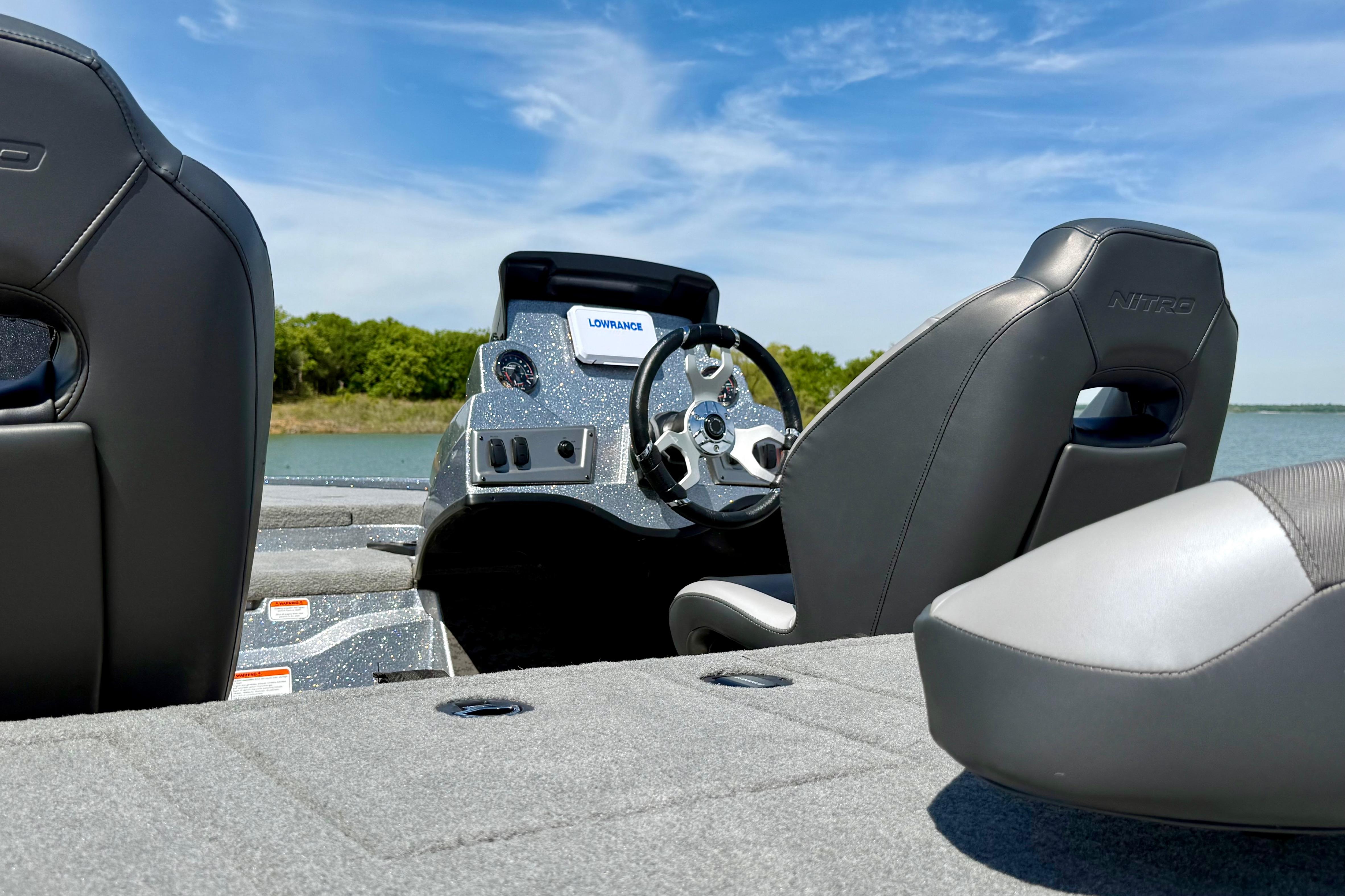 2026 Nitro Z19 XL boat interior with steering wheel and seats, under clear blue sky.