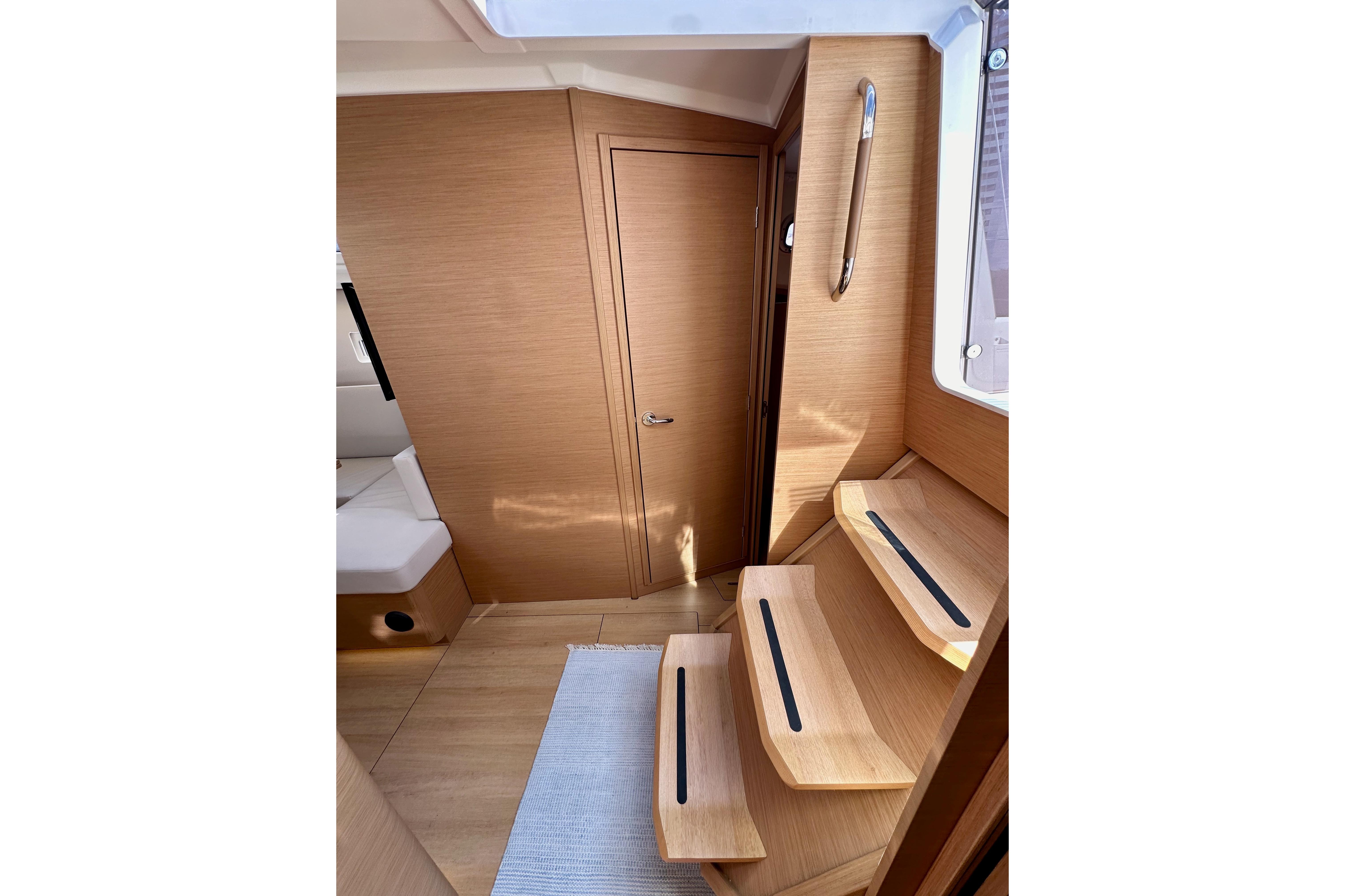 Interior of 2024 Jeanneau Sun Odyssey 410, featuring wooden steps and modern design.