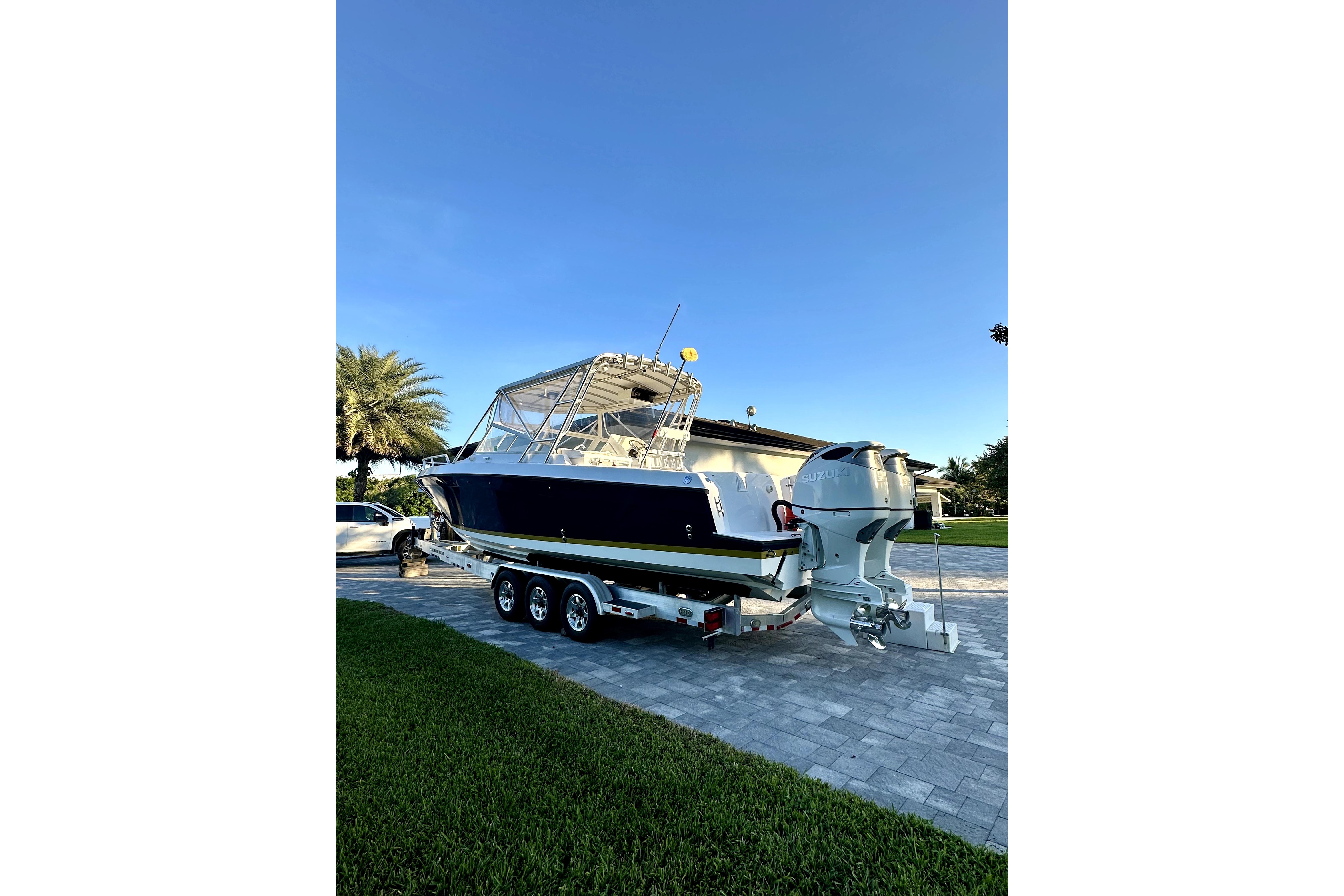2006 Contender 35 Express Side Console boat on trailer, parked in driveway.
