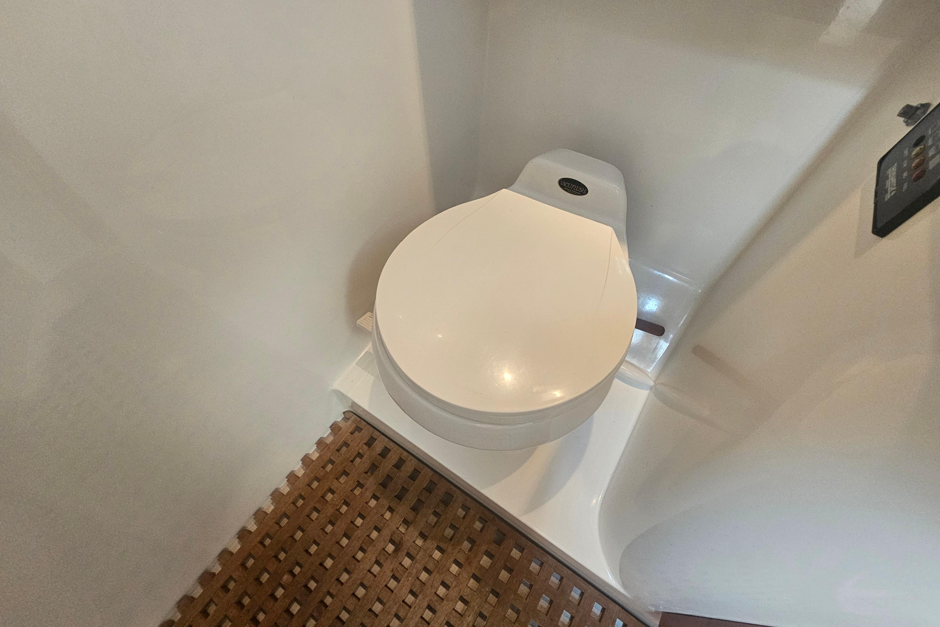 Toilet in 2003 Topaz 32 Express boat with wooden floor mat.