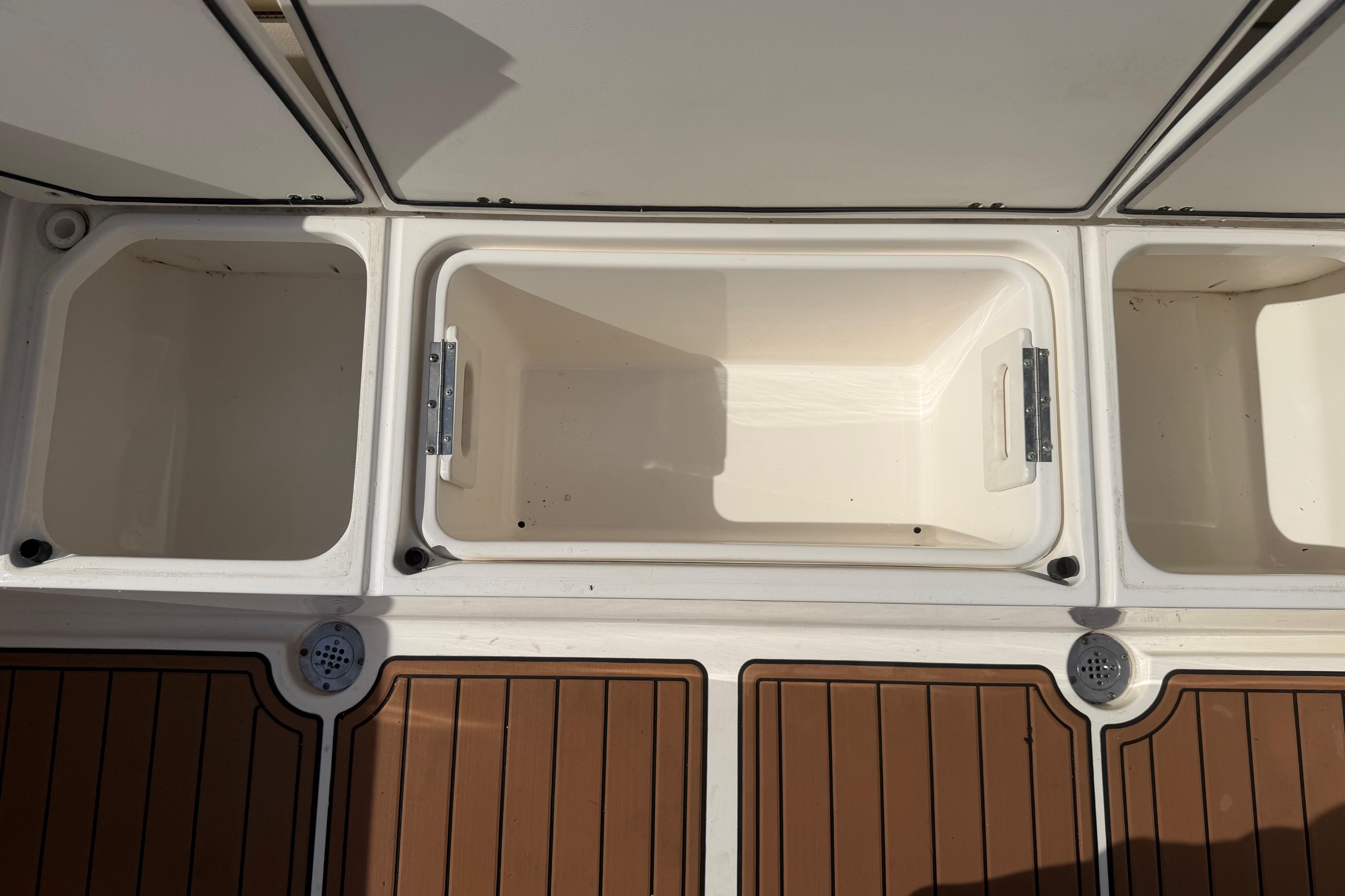 2019 Key West 263 FS boat storage compartments with teak flooring.