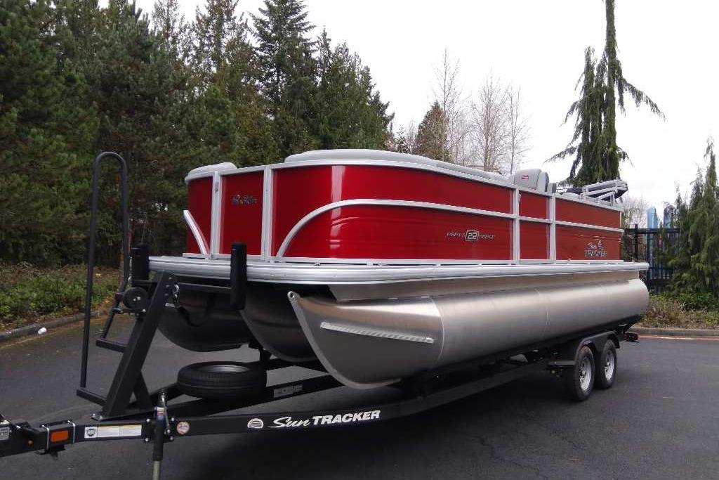 2026 Sun Tracker Party Barge 22 XP3 pontoon boat on trailer, parked outdoors.