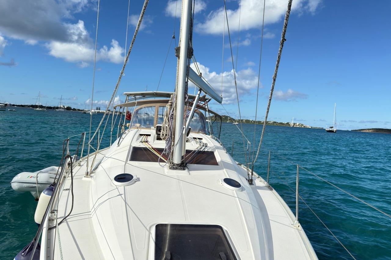 Sailing yacht Elan Impression 384, 2006 model, cruising on clear blue waters under a sunny sky.