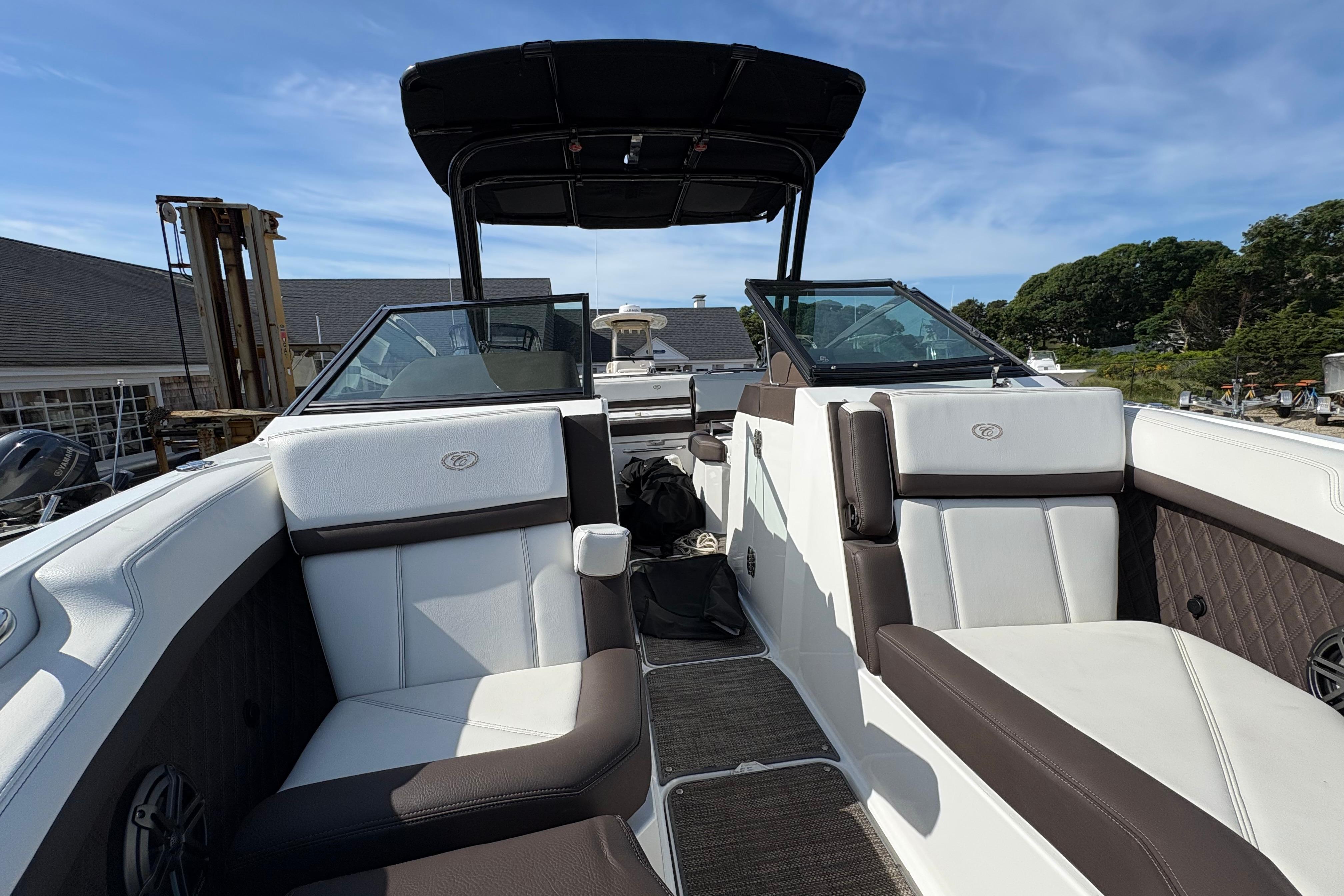2022 Cobalt R6 boat interior with white and brown seating, under a clear blue sky.