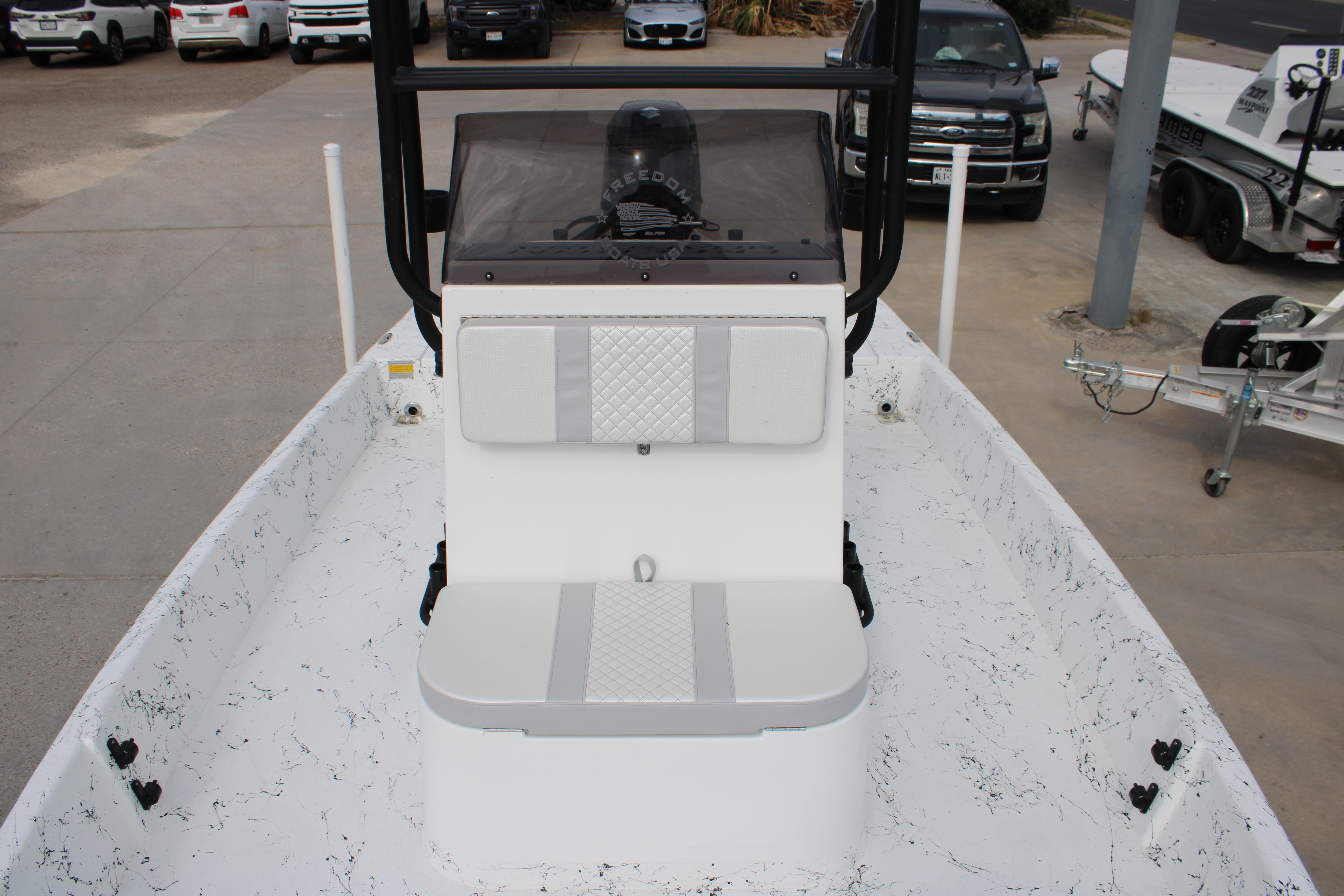 2026 Freedom Boats 19 PATRIOT interior with seating and console, parked outdoors.