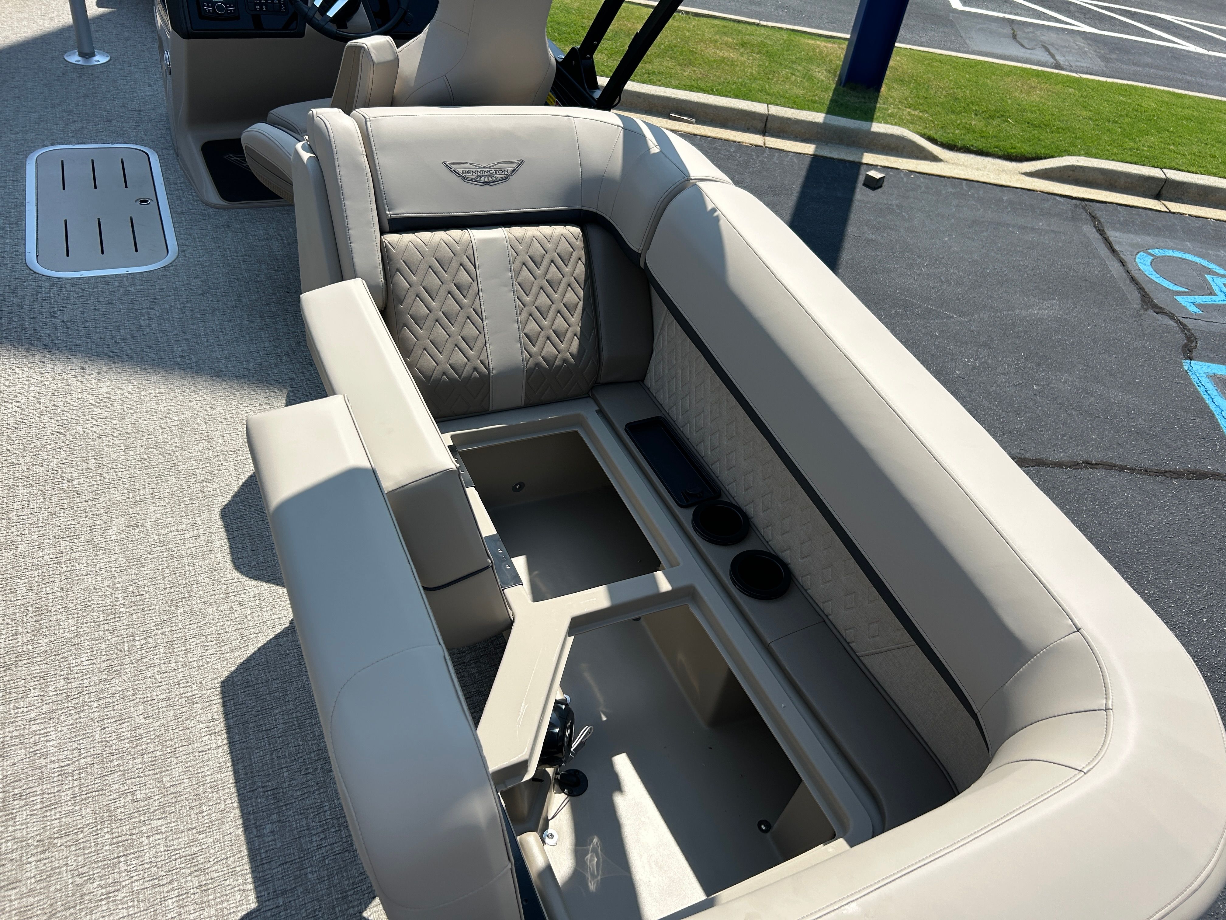Interior of a Bennington 22 MFB boat with beige upholstery and storage space.