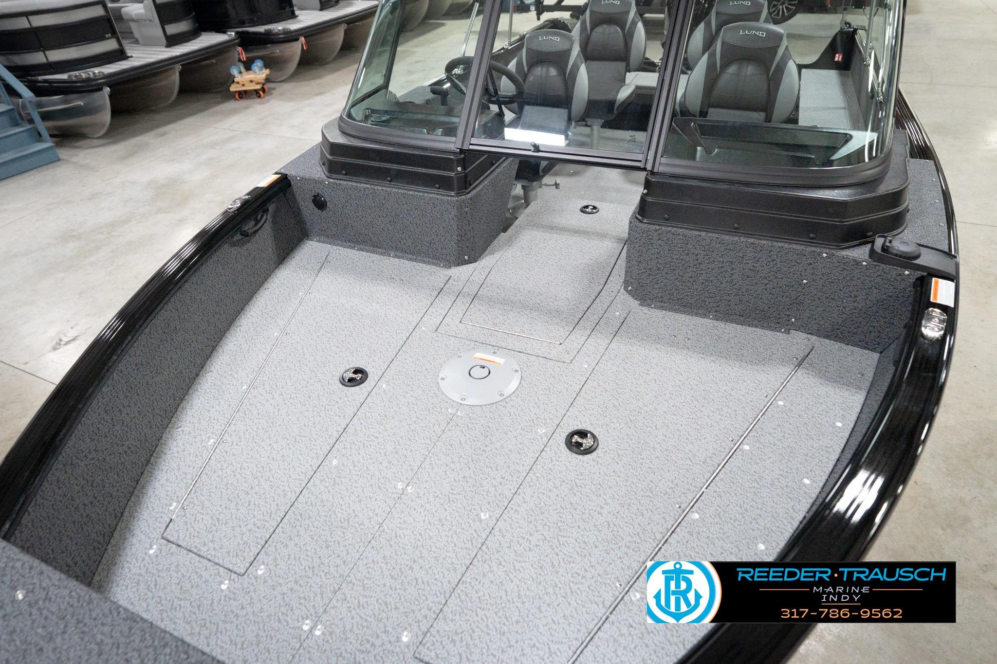 2026 Lund 1800 Explorer Sport boat interior with seating and windshield in showroom.