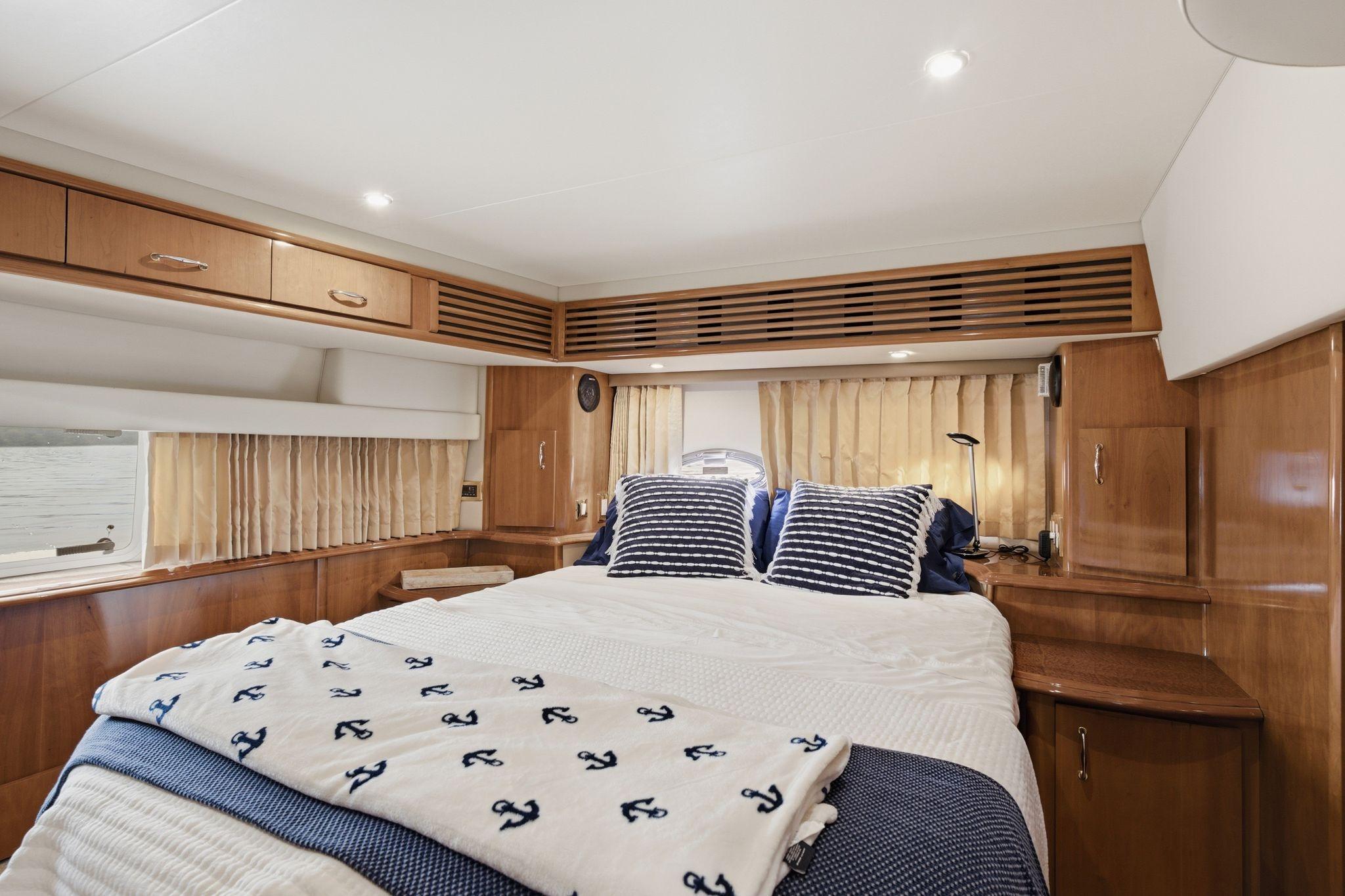 Luxurious bedroom interior of 2005 Carver 39 Motor Yacht with nautical-themed decor.