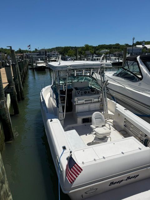 A 1995 Pro-Line 2950 Walkaround docked. It features an open cockpit and helm console.