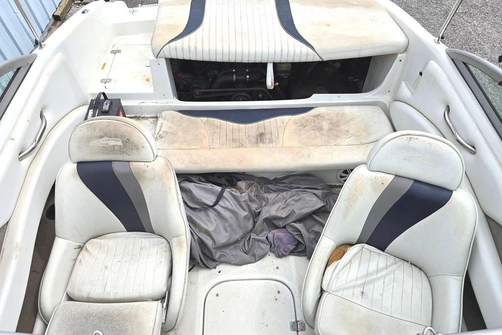 2003 Caravelle 187 Bow Rider interior with worn seats and storage area.