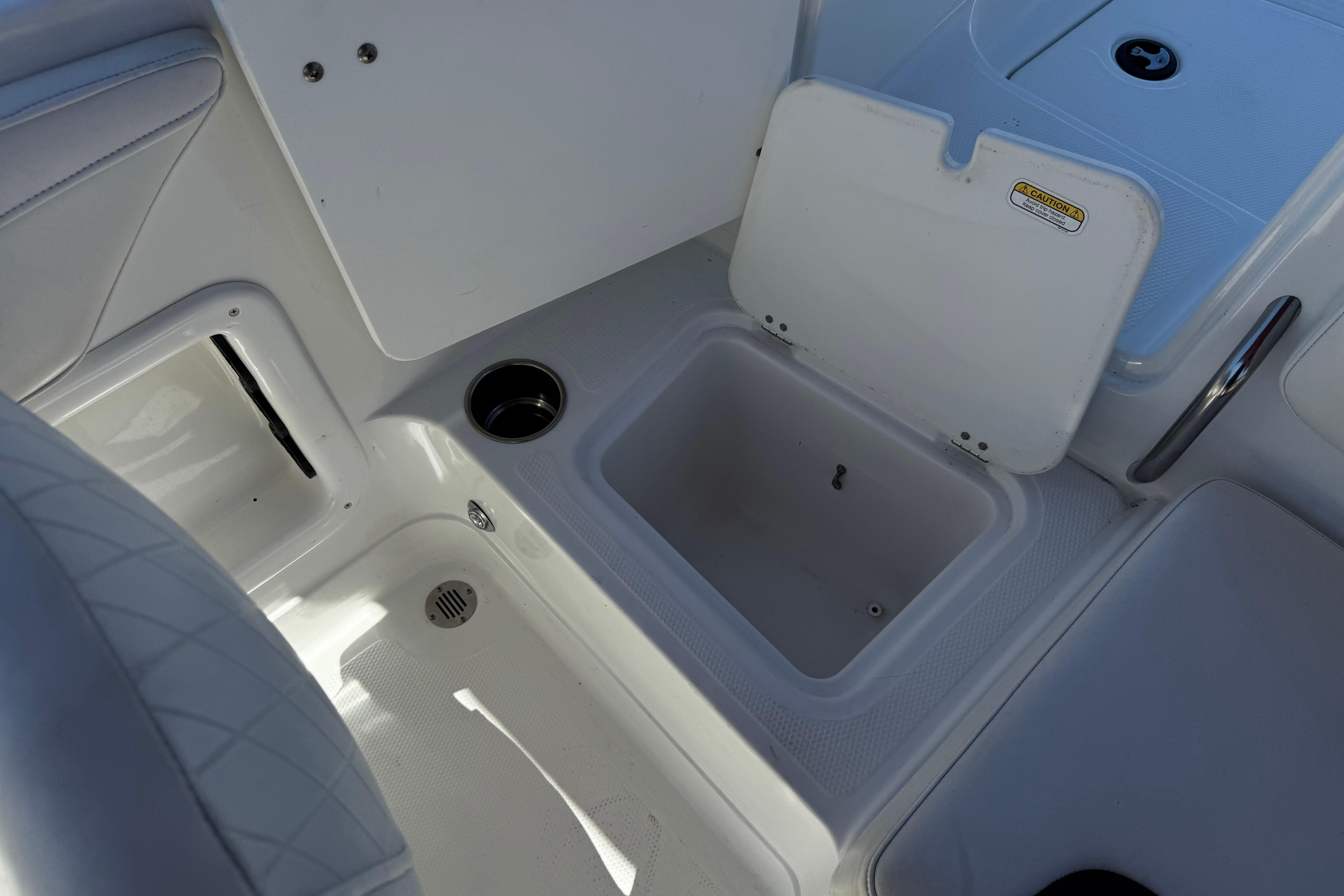 2017 Tahoe 2150 boat interior with open storage compartment and cup holder.