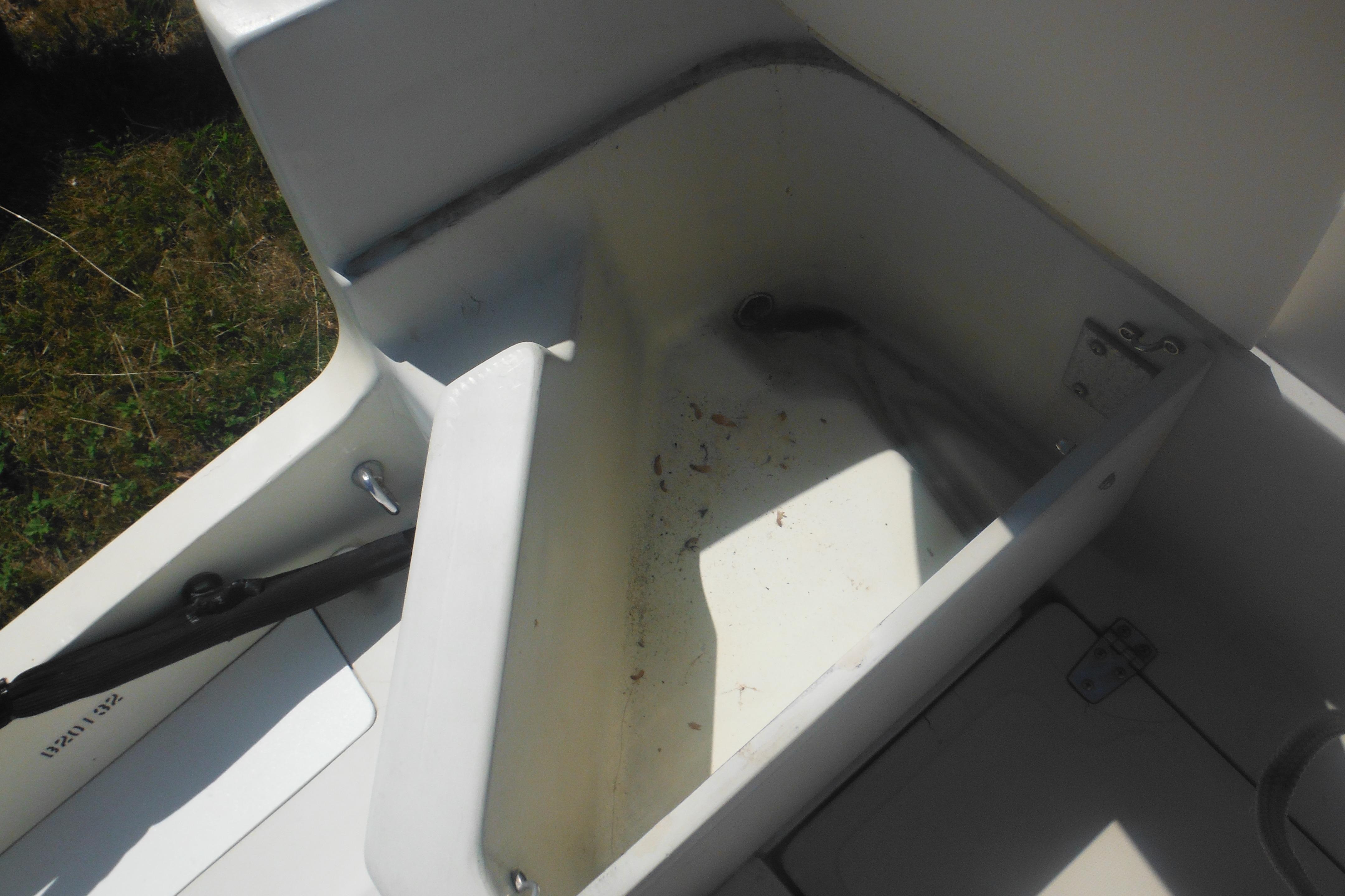 1991 Boston Whaler 16 SL boat interior storage compartment, open and empty.