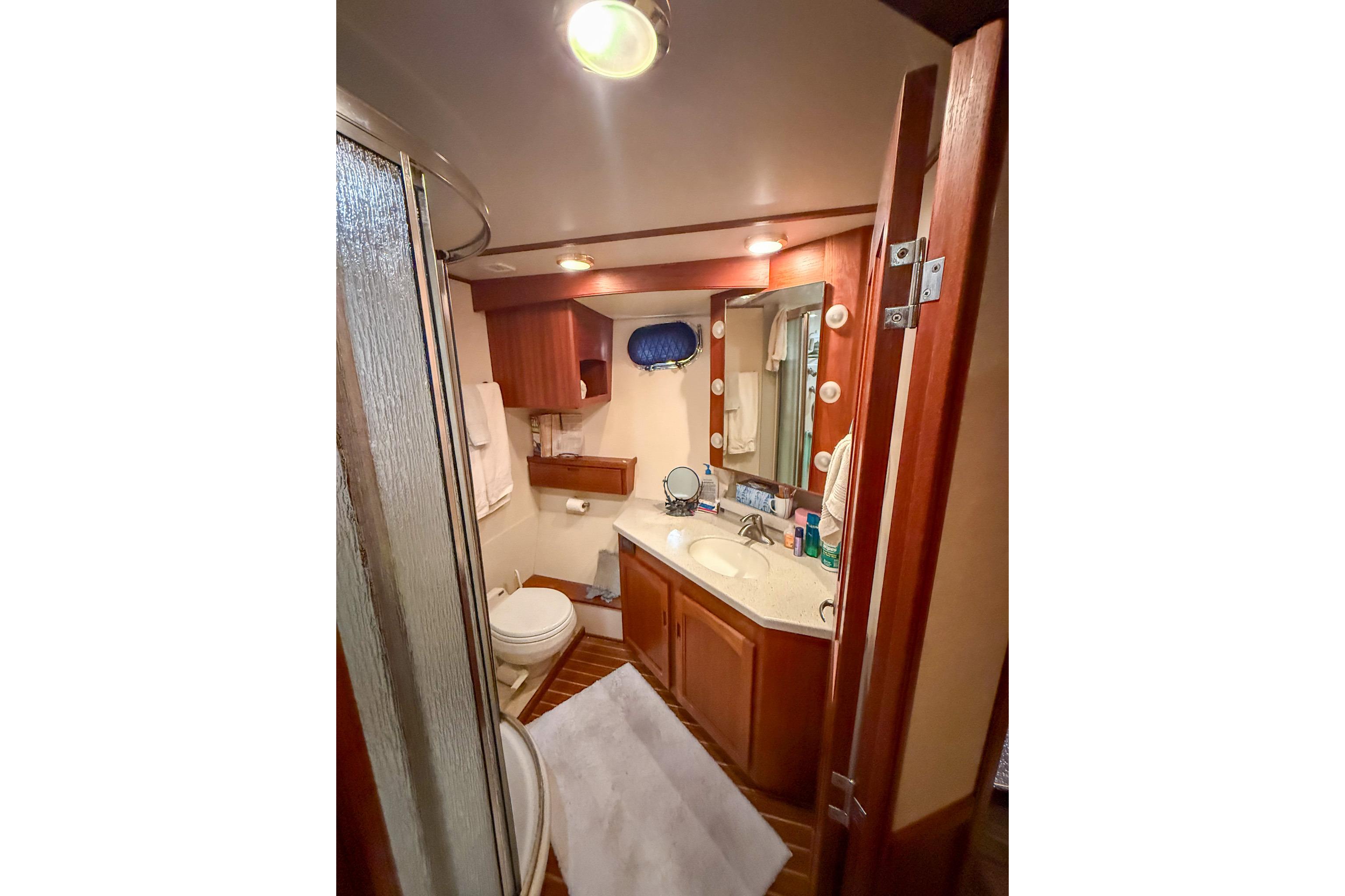 Luxurious bathroom in 2007 Nordic Tug 54 yacht with wood accents and modern amenities.