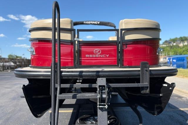2025 Regency 250 DL3 pontoon boat, red exterior, parked on a trailer under a clear sky.