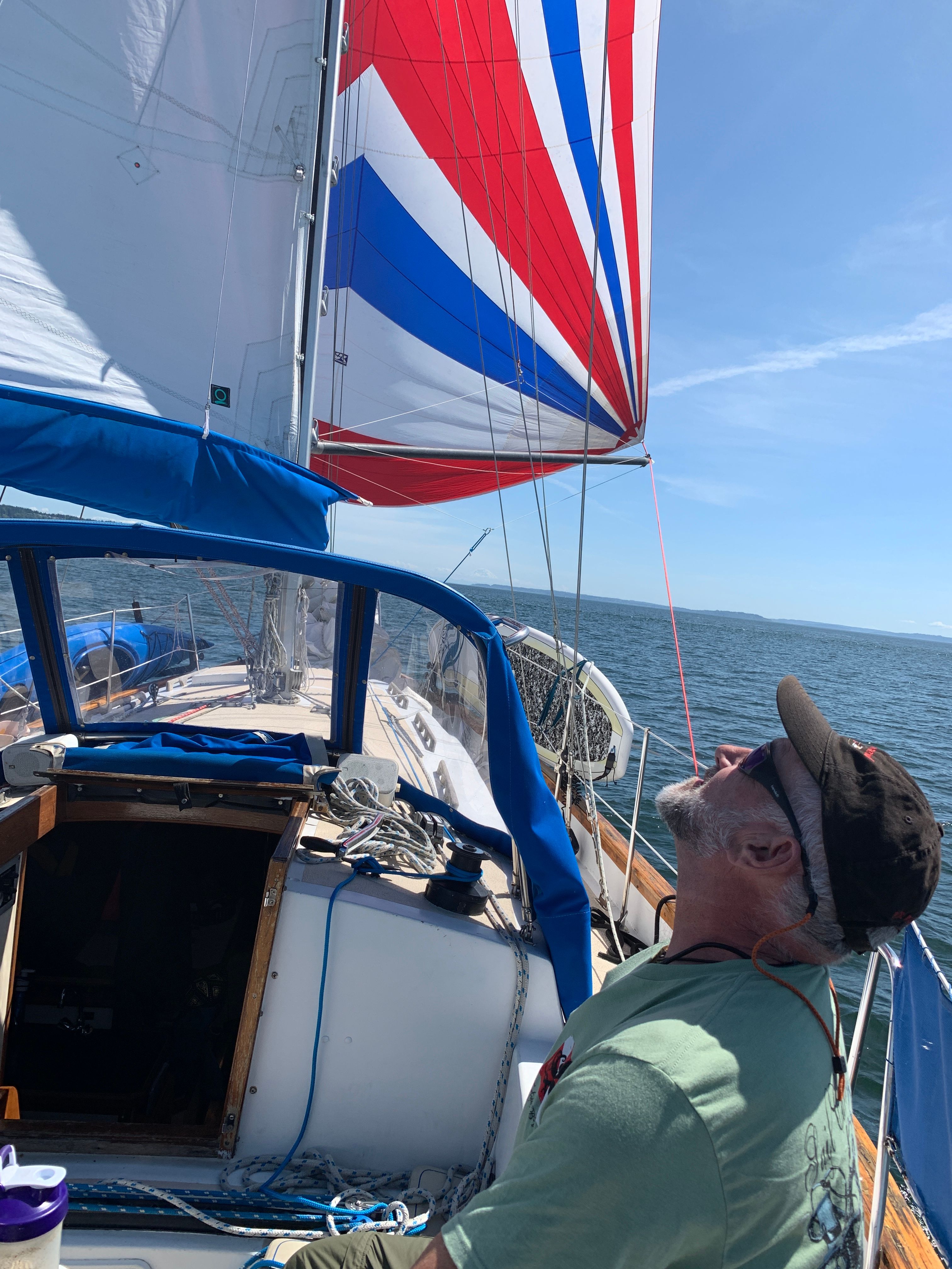 Man on sailboat with colorful sail, Custom 341, 1994.