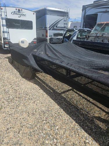 A 2011 Premier 275 Grand Majestic PTX is covered with a tarp, parked on a gravel lot.