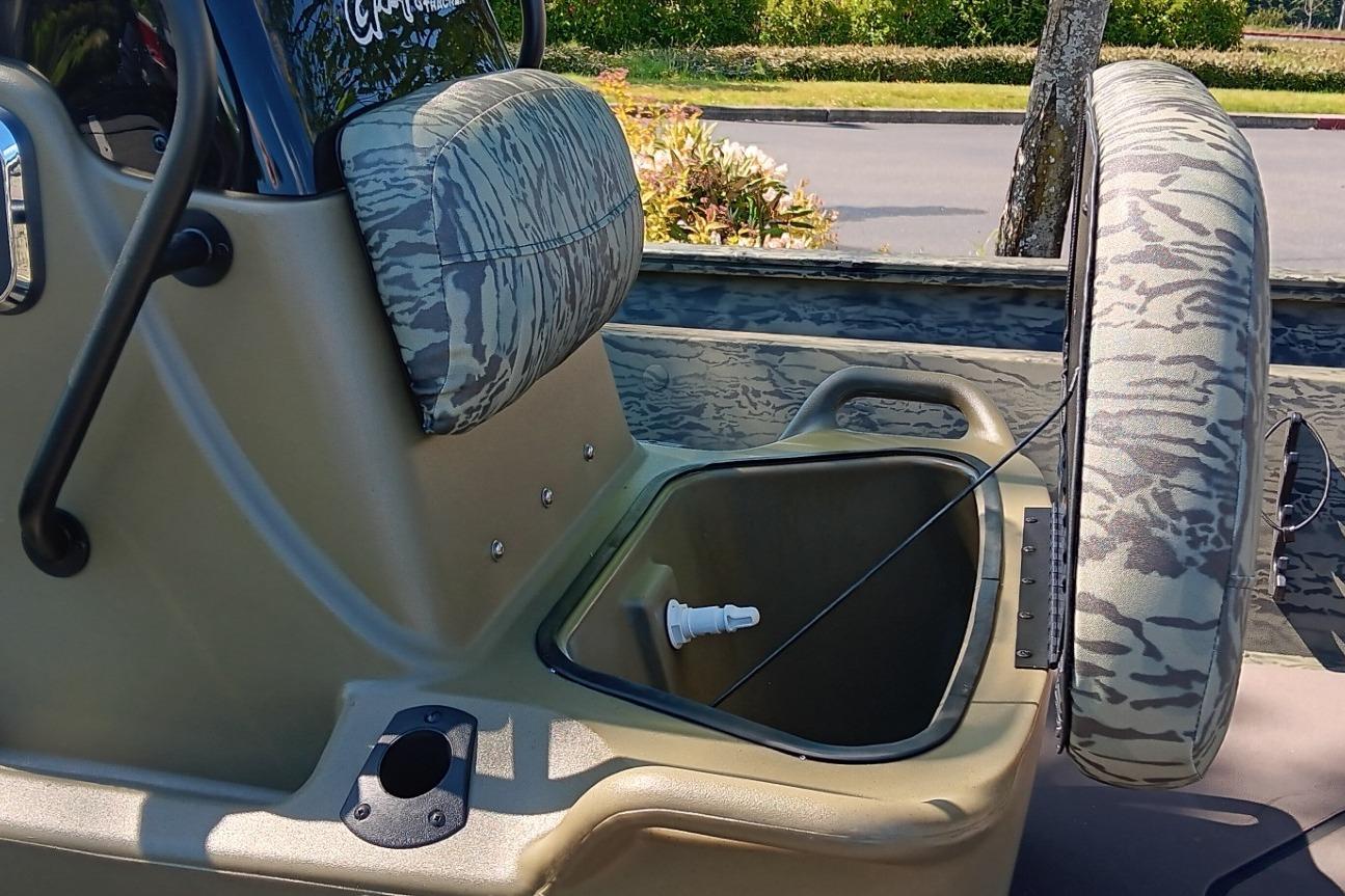 2026 Tracker Grizzly 1860 CC boat interior with camo seats and storage compartment.