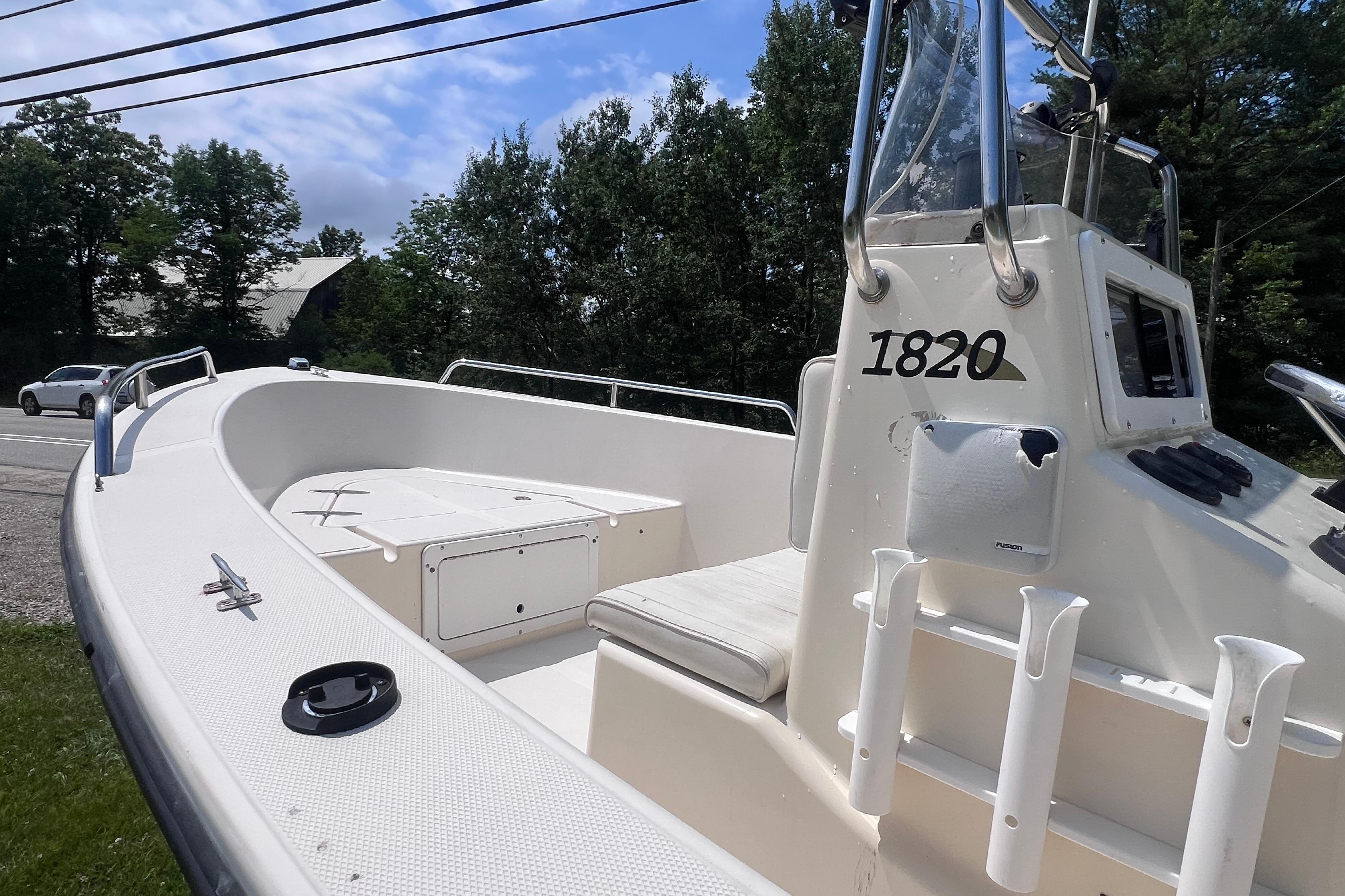 2003 May-Craft 1820CC boat with open deck and console, parked outdoors.
