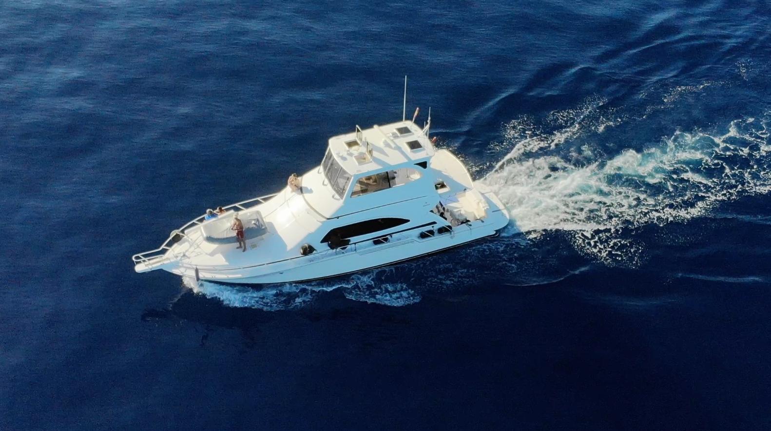 2004 Bertram 510 yacht cruising on open blue sea, aerial view.