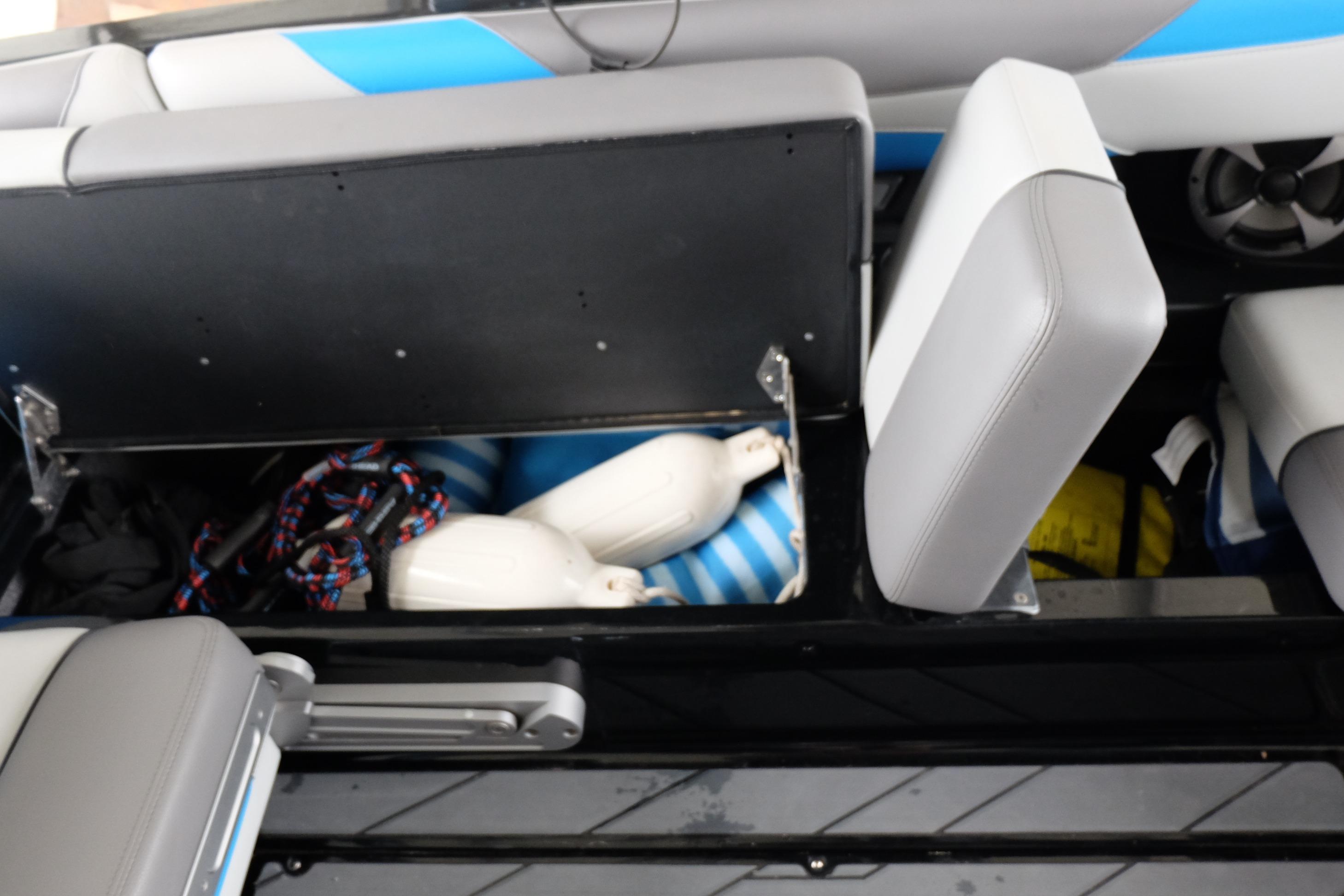 Open storage compartment in 2020 Malibu Wakesetter 23 LSV boat with boating accessories.