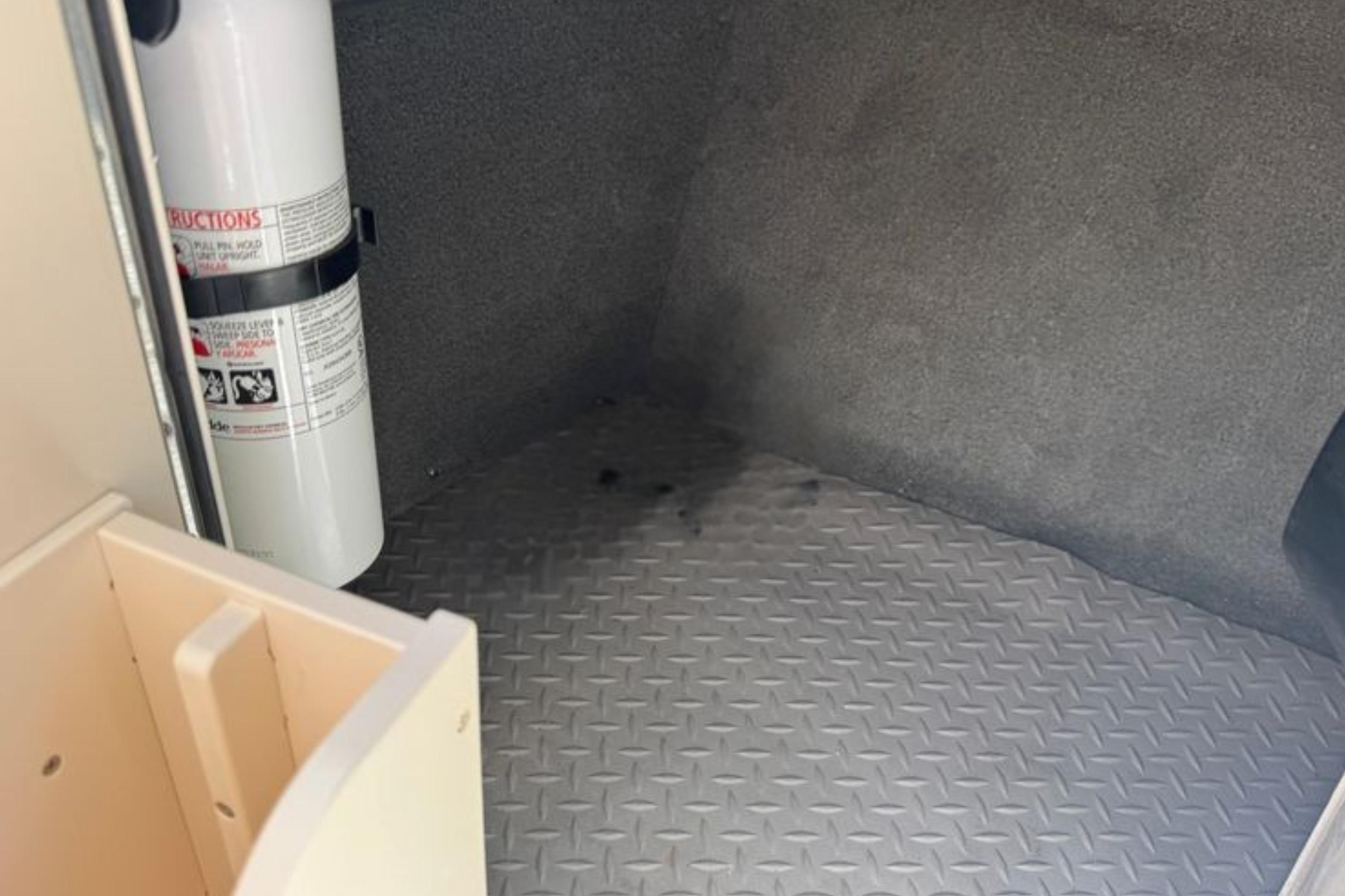 Interior of 2017 Grady-White Freedom 235 boat with fire extinguisher and textured flooring.