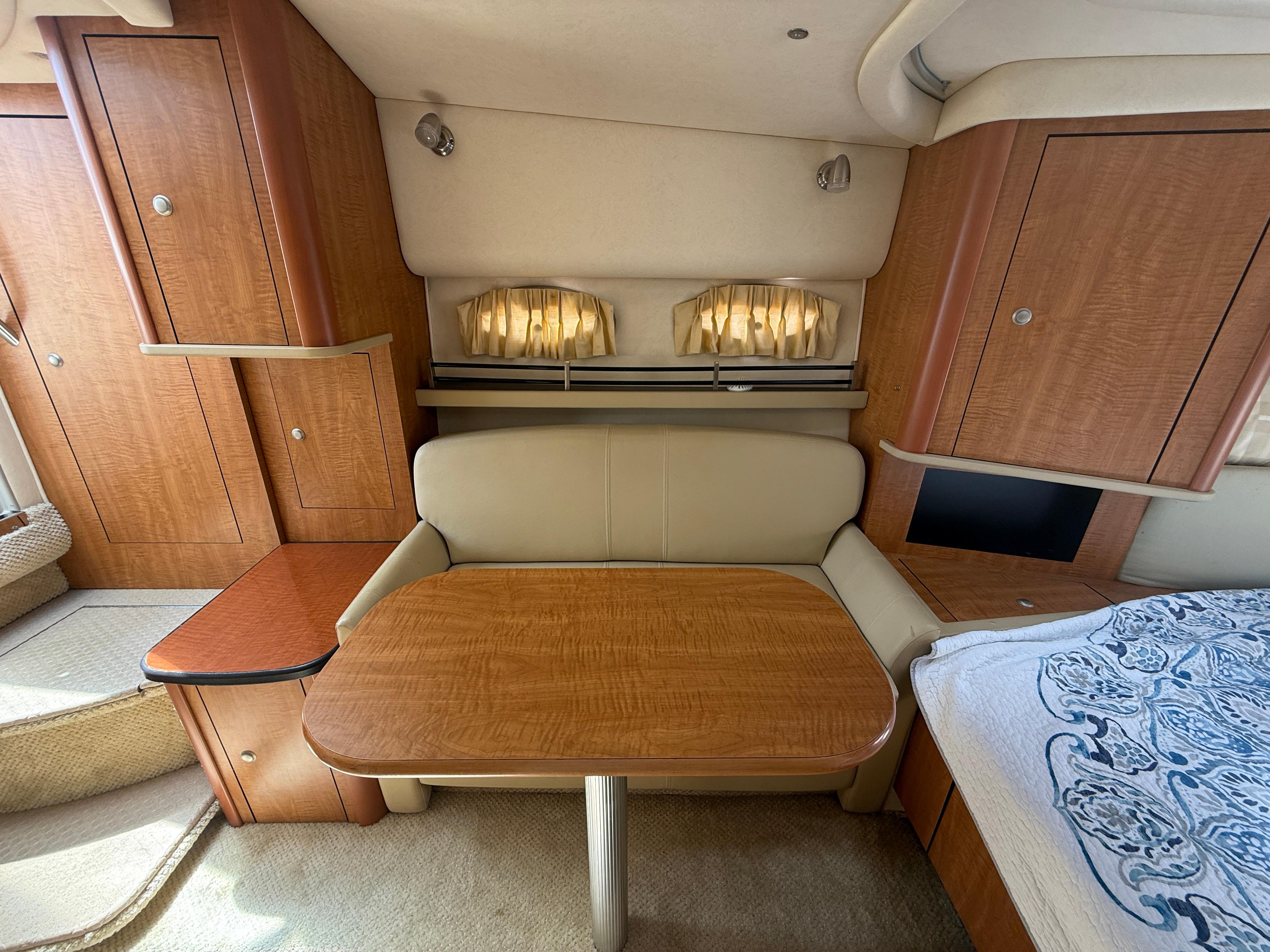 2006 Sea Ray 290 Sundancer cabin interior with wooden table and seating area.