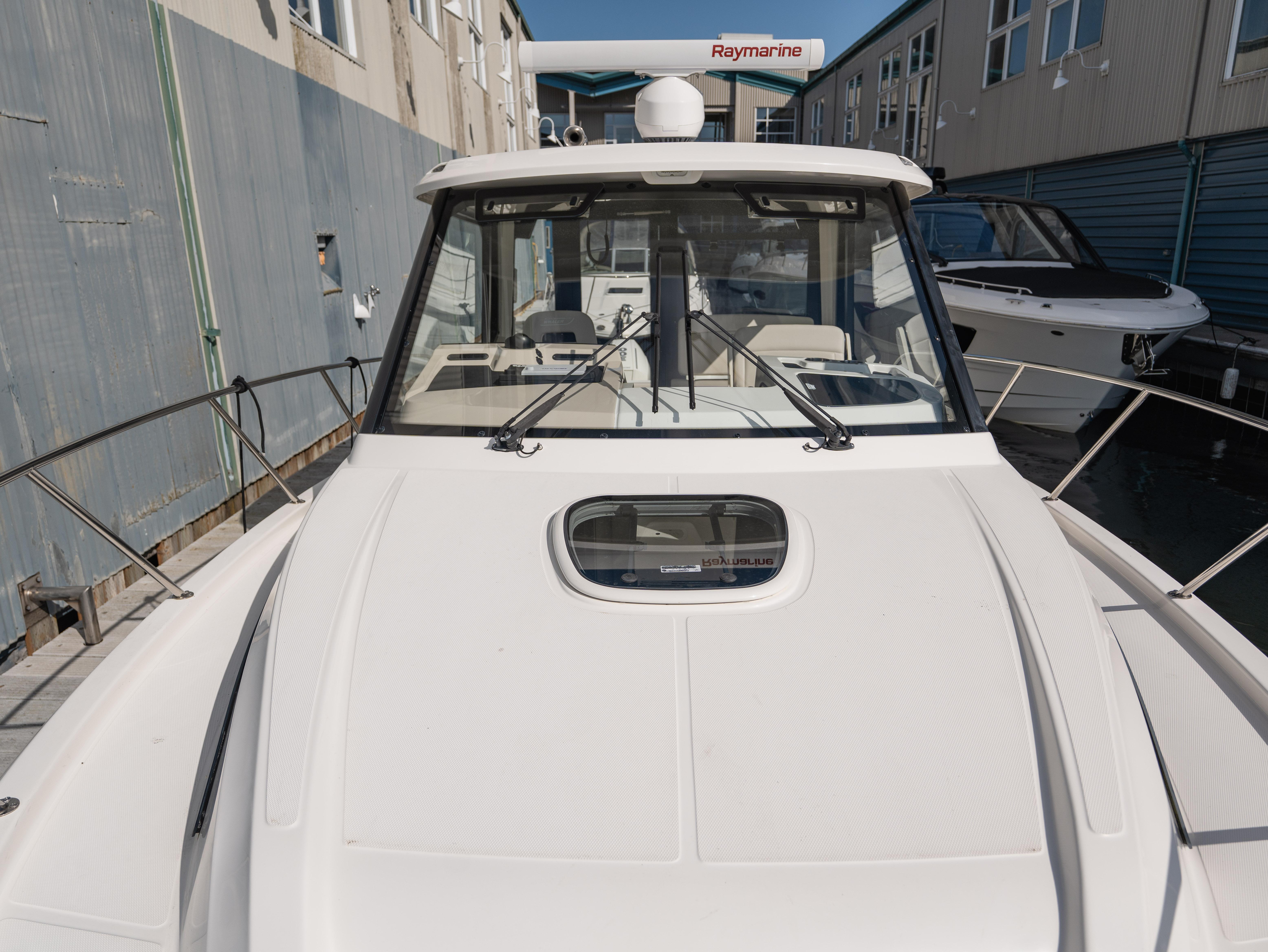 2020 Boston Whaler 325 Conquest Pilothouse boat docked, showcasing sleek design and pilothouse.