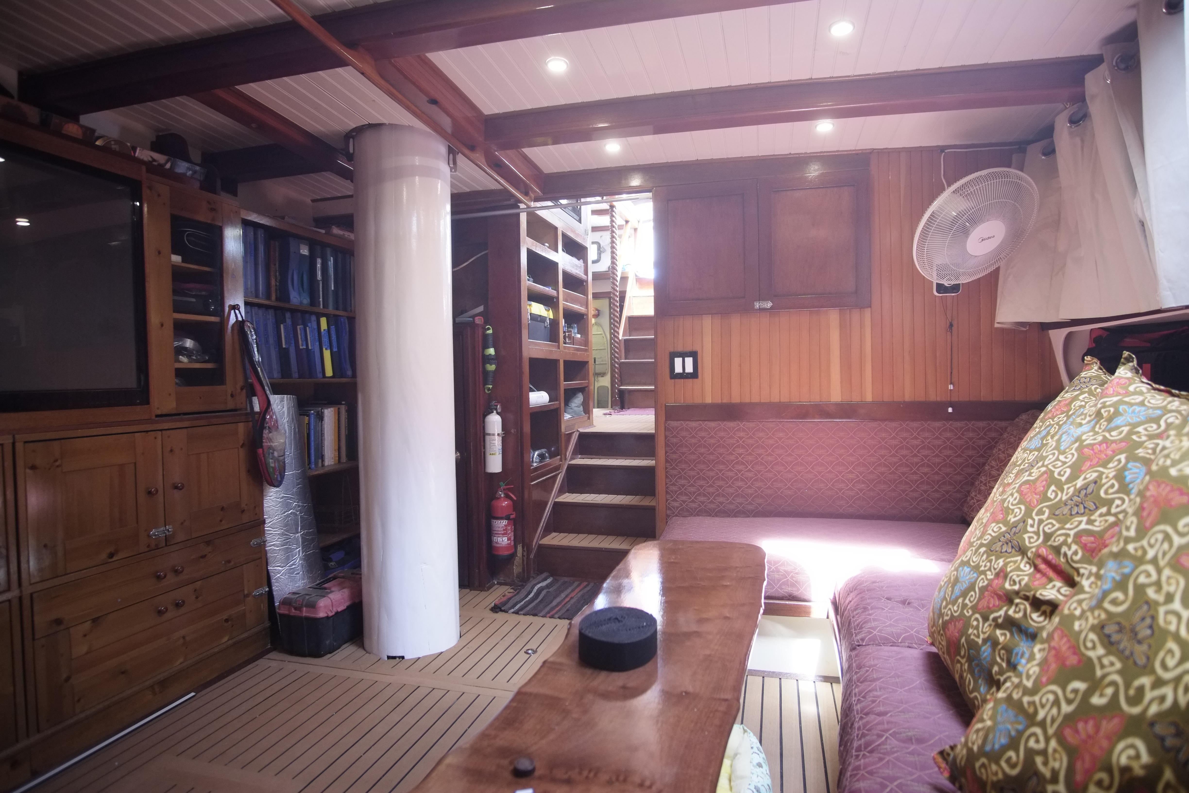 Interior of 2006 Custom Bud Macintosh schooner with wooden furnishings and cozy seating area.