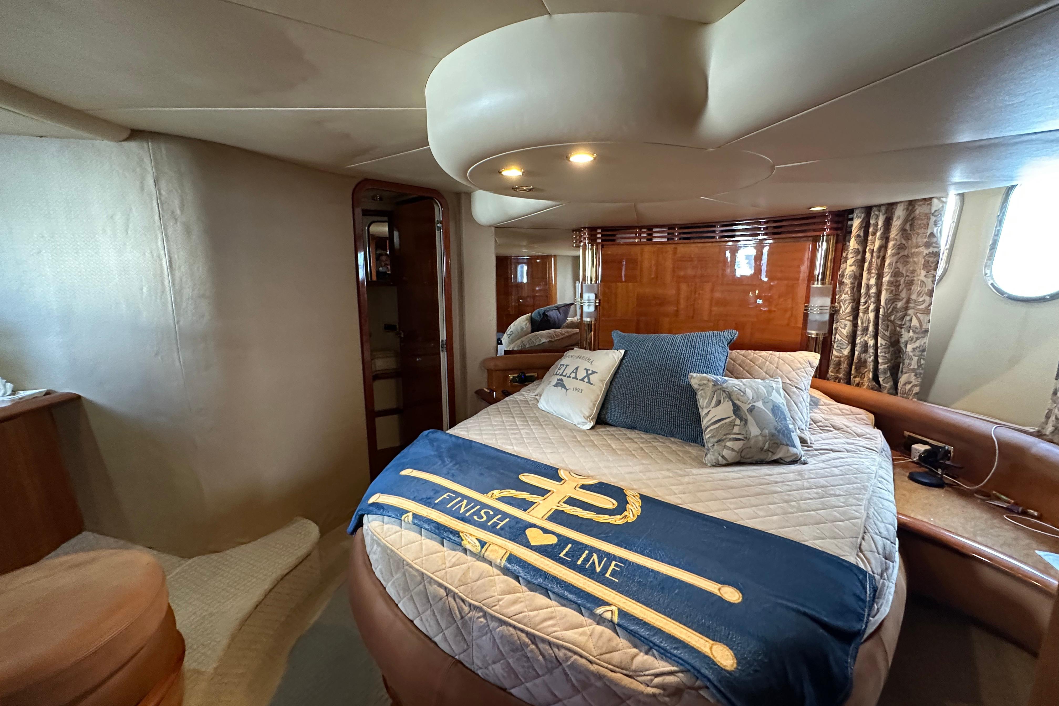 Luxurious cabin interior of a 2004 Azimut 55E yacht with elegant bedding and decor.