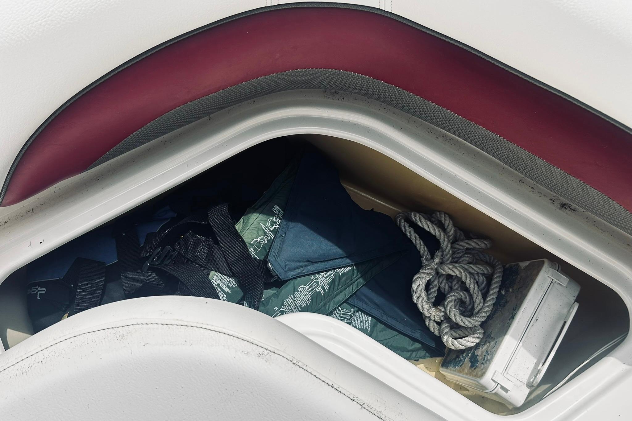 Storage compartment in a 2013 Hurricane SunDeck Sport 201 OB boat with ropes and gear.