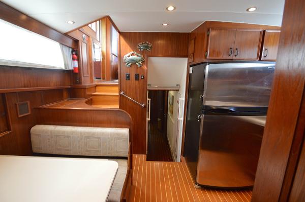 Interior of a 1980 Hatteras 53 Yacht Fisherman with wood paneling and stainless steel appliances.