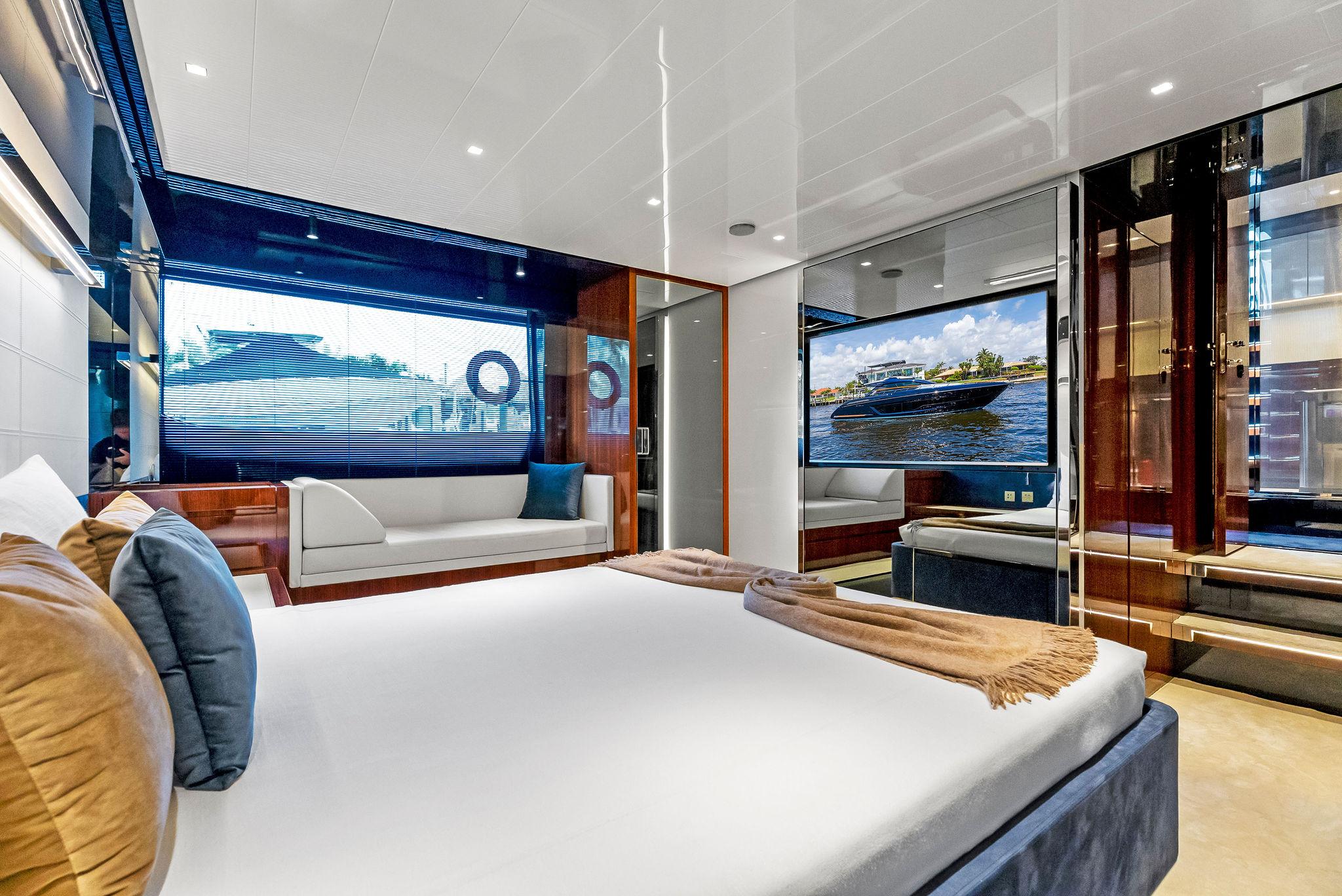 Luxurious bedroom interior of 2020 Riva 66' Ribelle yacht with modern decor and large windows.