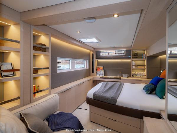 Luxurious interior of 2025 Lagoon 55 yacht with modern design and cozy bedroom.