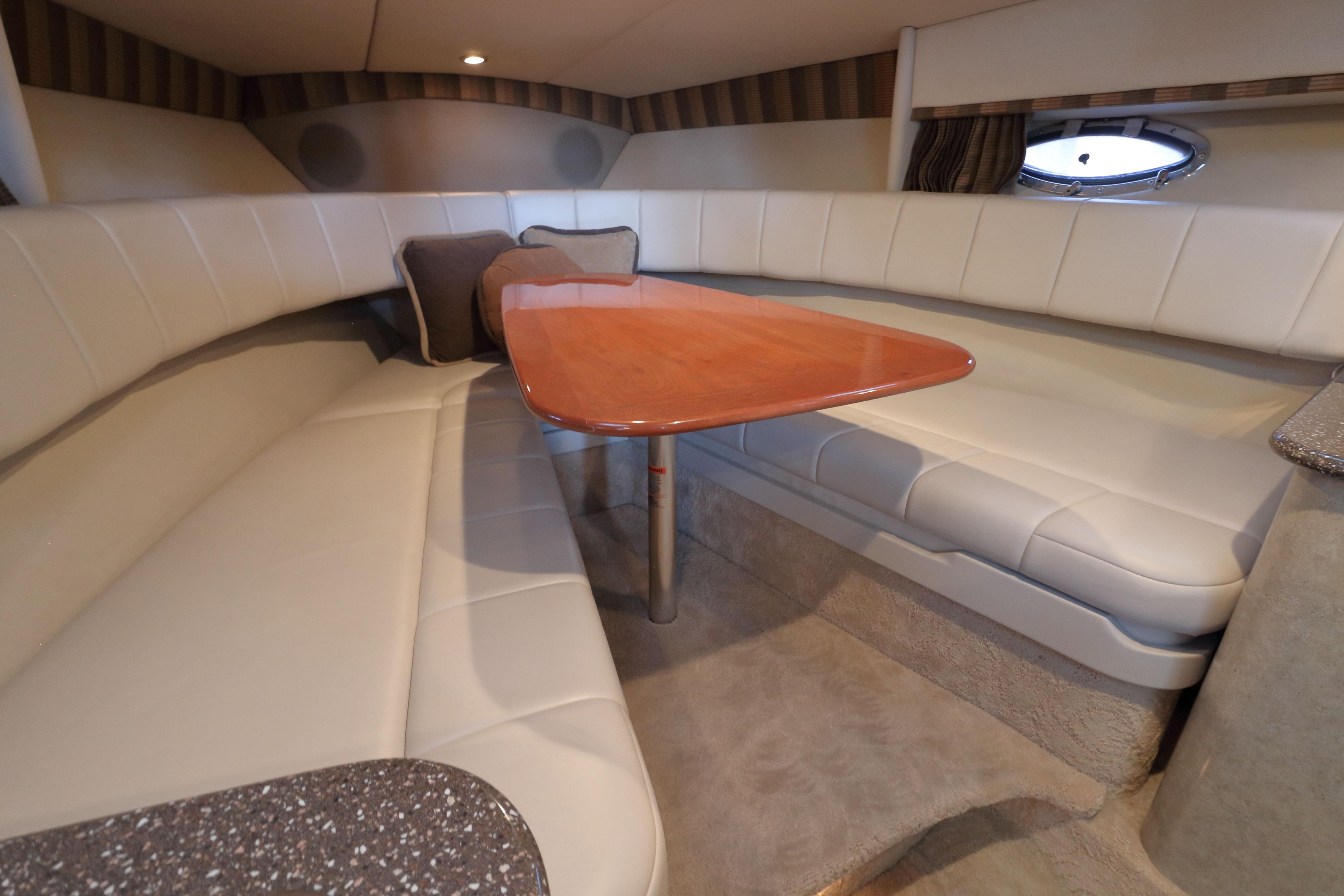 Interior of 2006 Formula 330 Sun Sport boat with plush seating and wooden table.