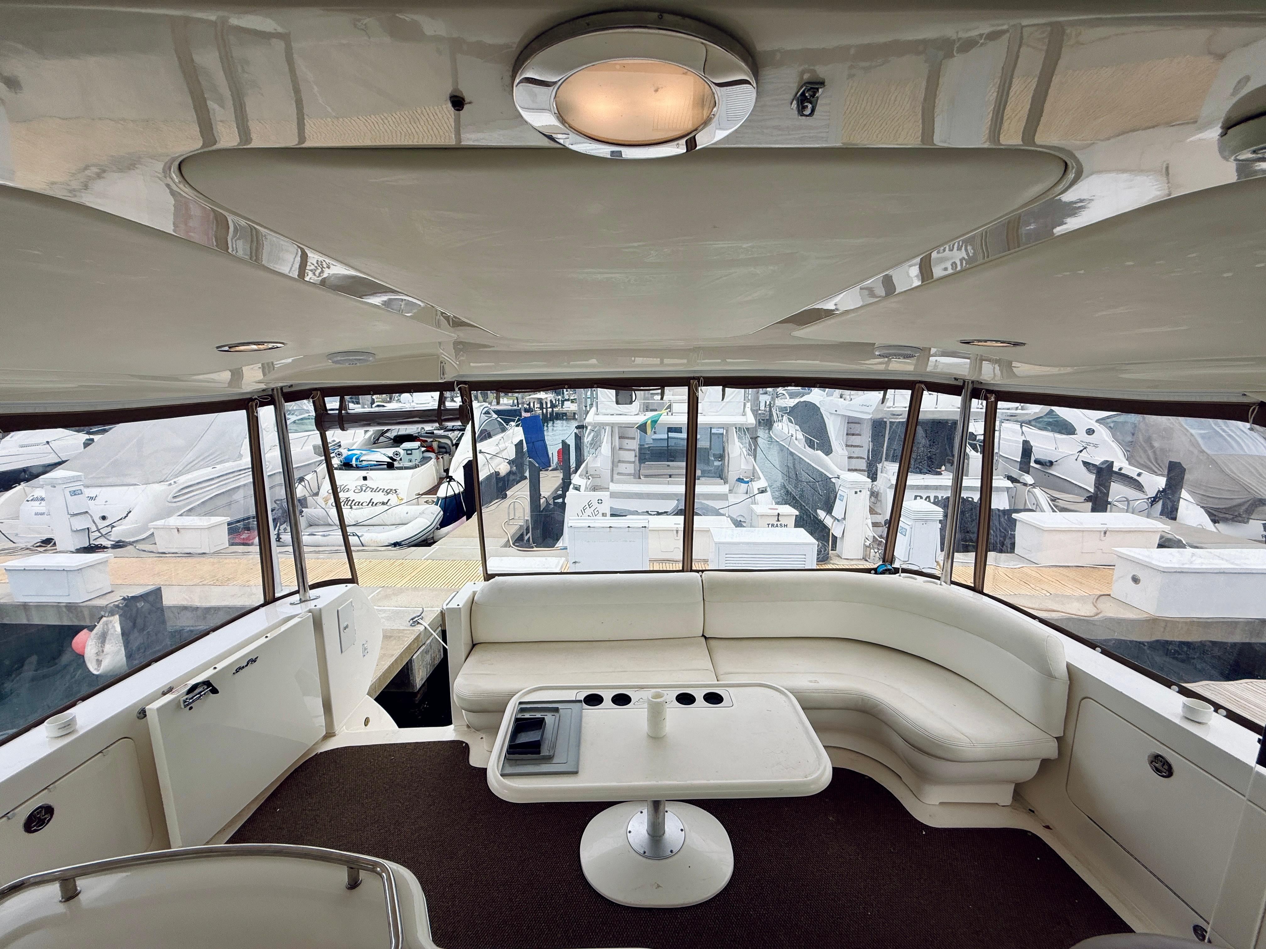 2003 Sea Ray 480 Motor Yacht interior with white seating and marina view.