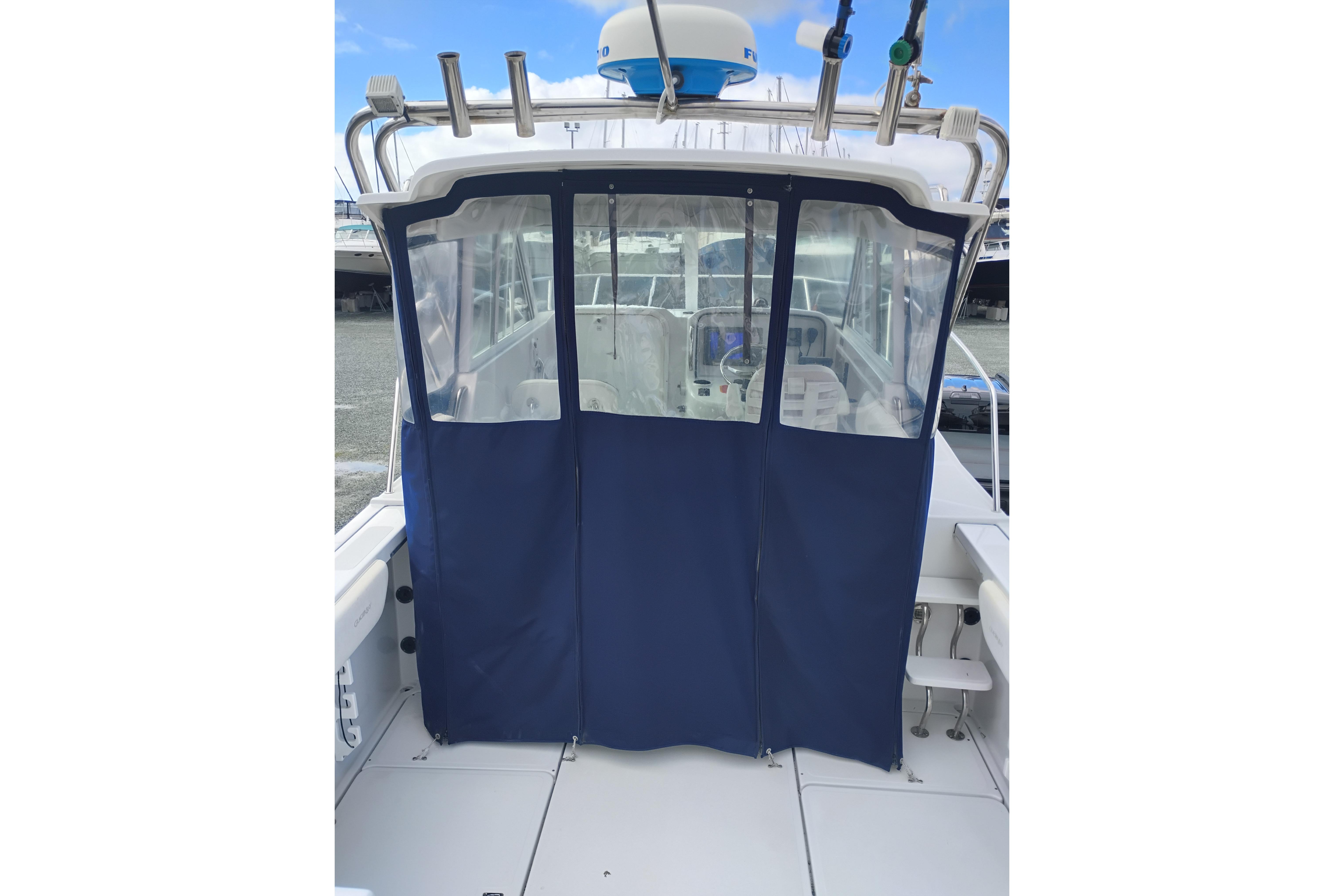 2007 Glacier Bay 2685 Coastal Runner with blue canvas enclosure and fishing rod holders.
