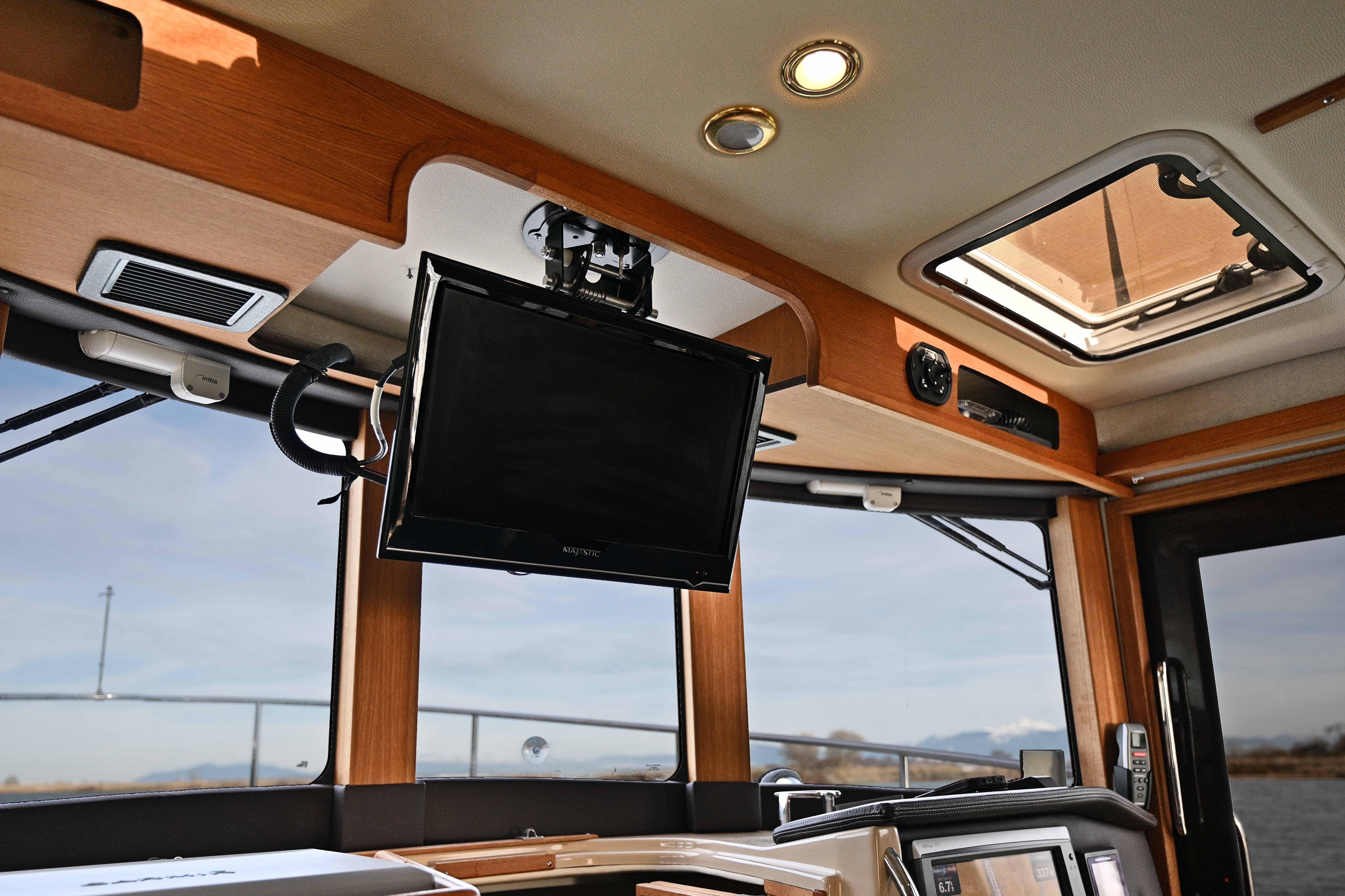 Interior of 2014 Ranger Tug R-31 CB with mounted TV and skylight.