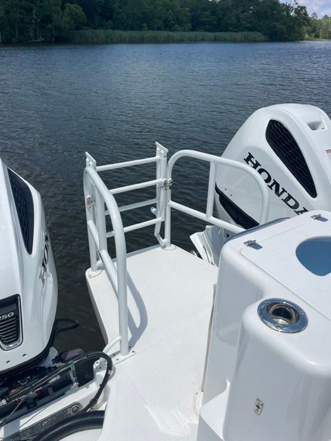 The image shows the stern of an ArrowCat 320 with two Honda outboard motors on calm water.