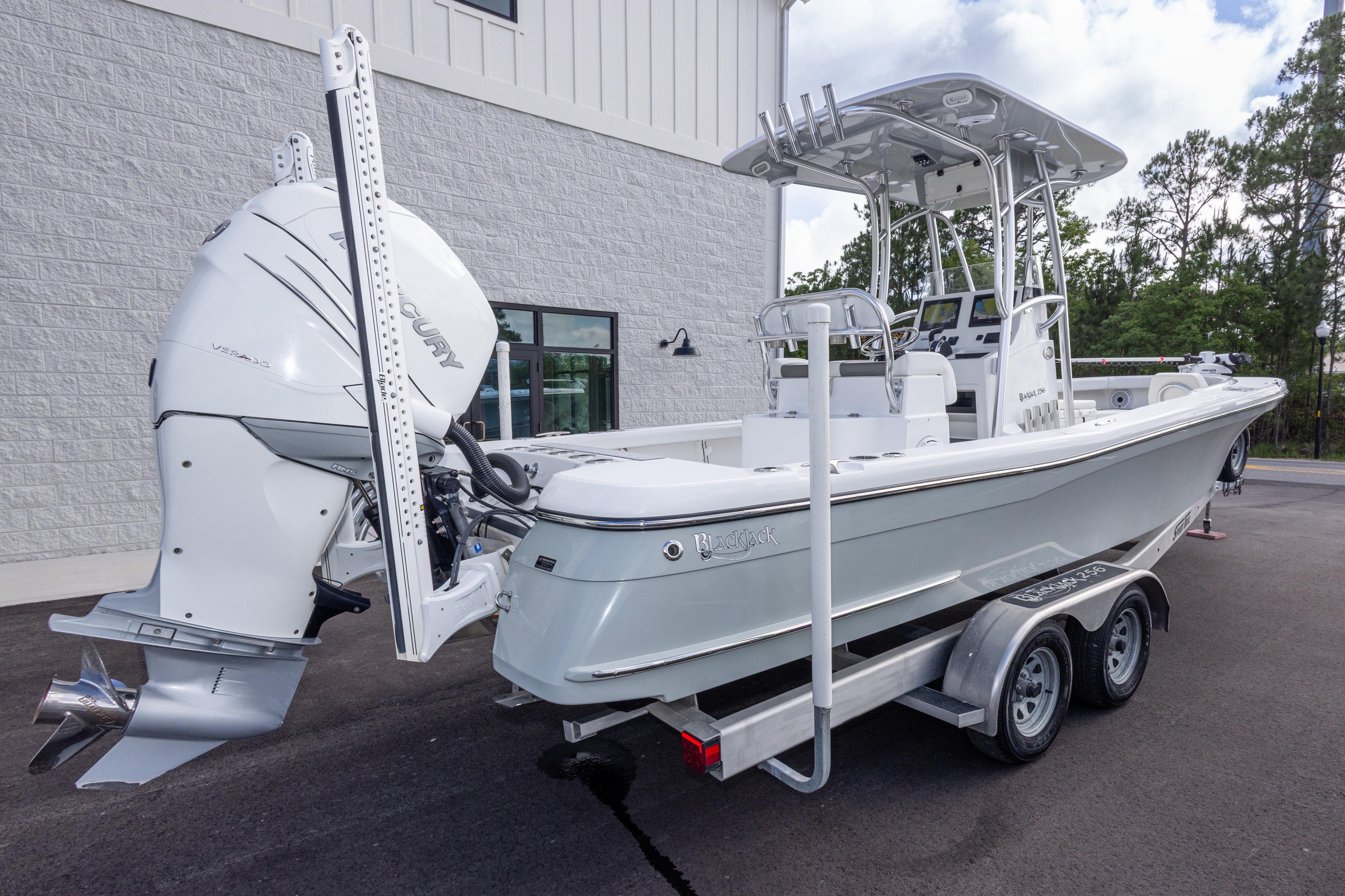 2022 BlackJack 256 Coastal boat with Mercury engine on a trailer, parked outdoors.