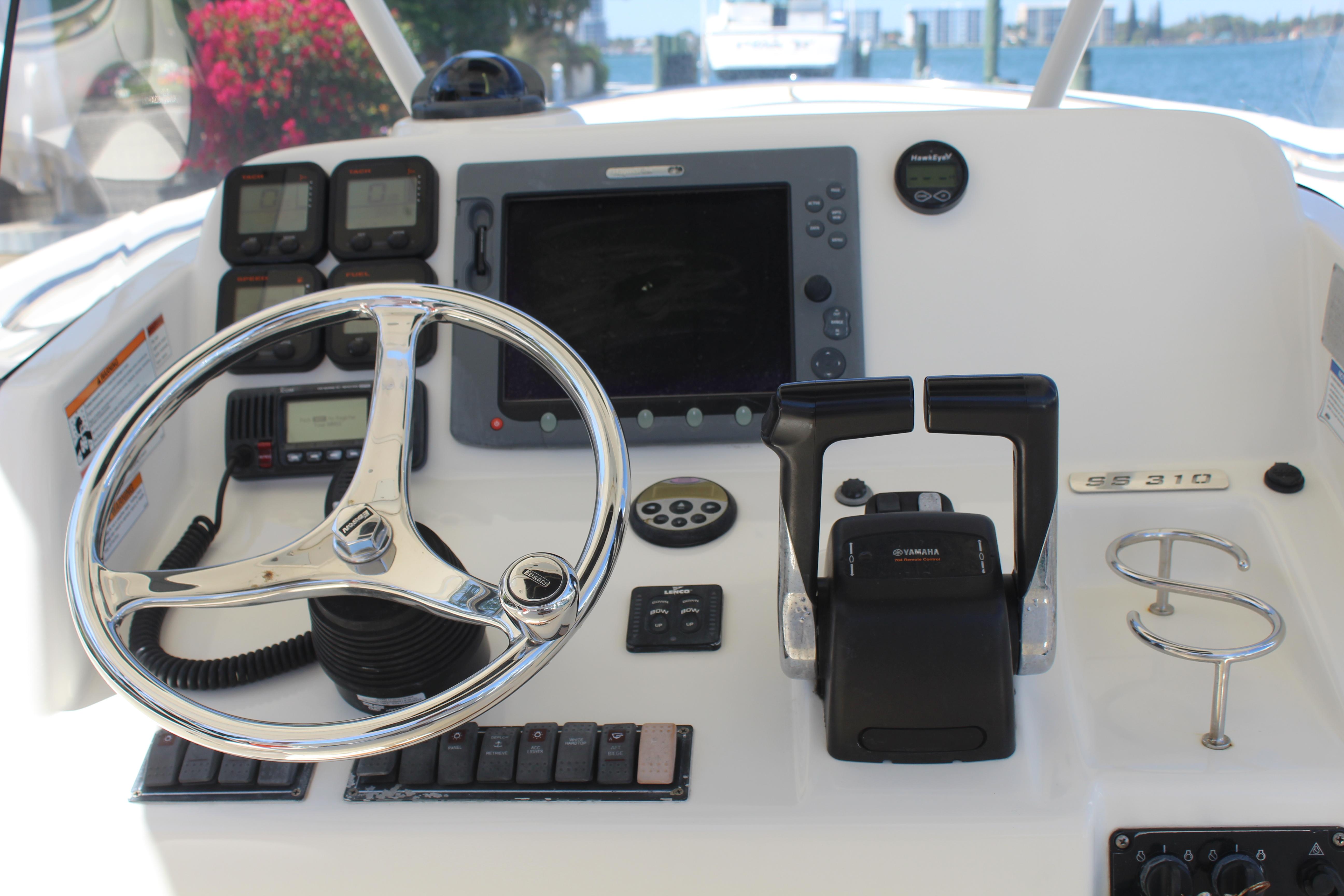 2008 Pursuit S 310 Sport boat dashboard with steering wheel and navigation controls.