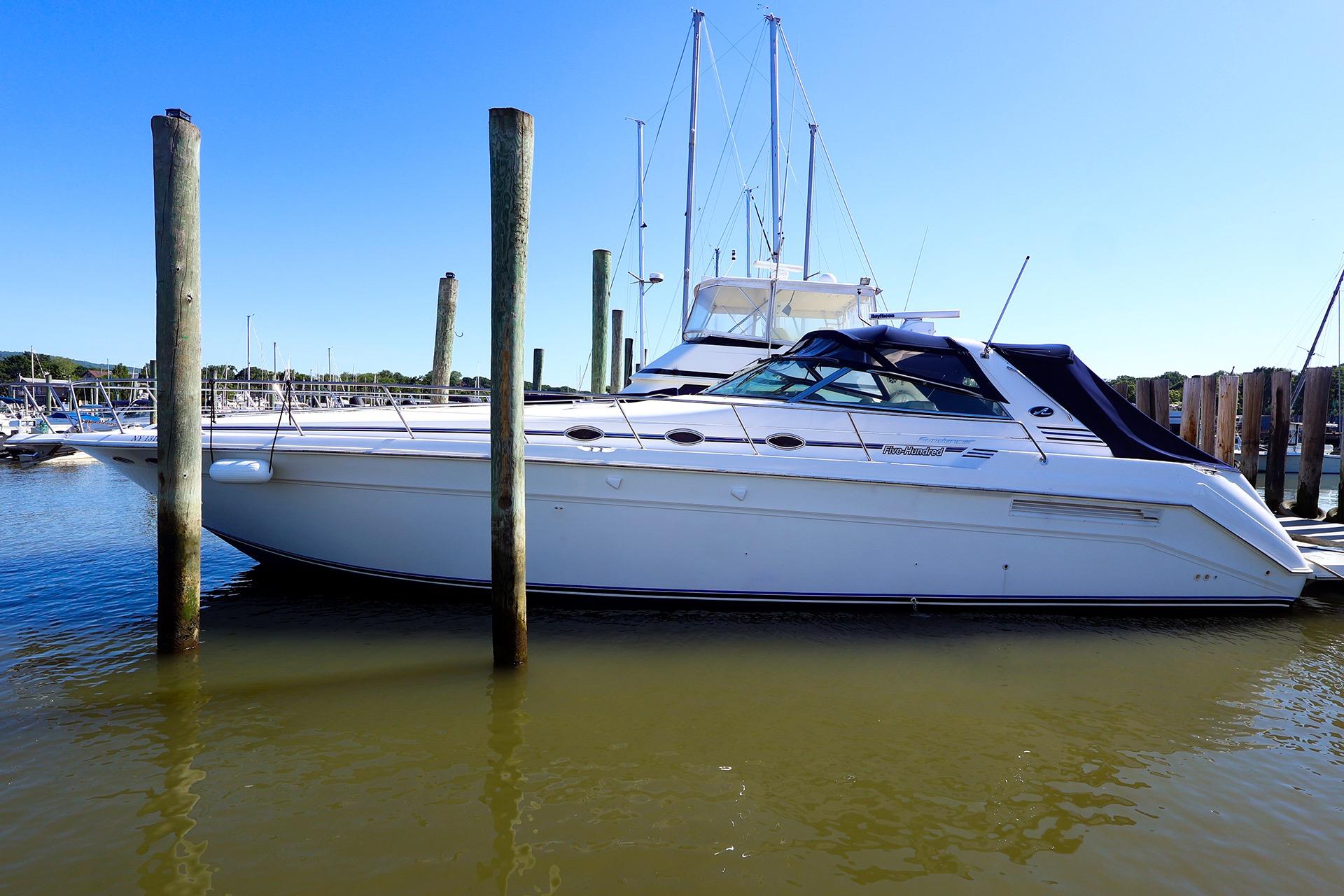1998 Sea Ray 500 Sundancer yacht docked at marina under clear blue sky.
