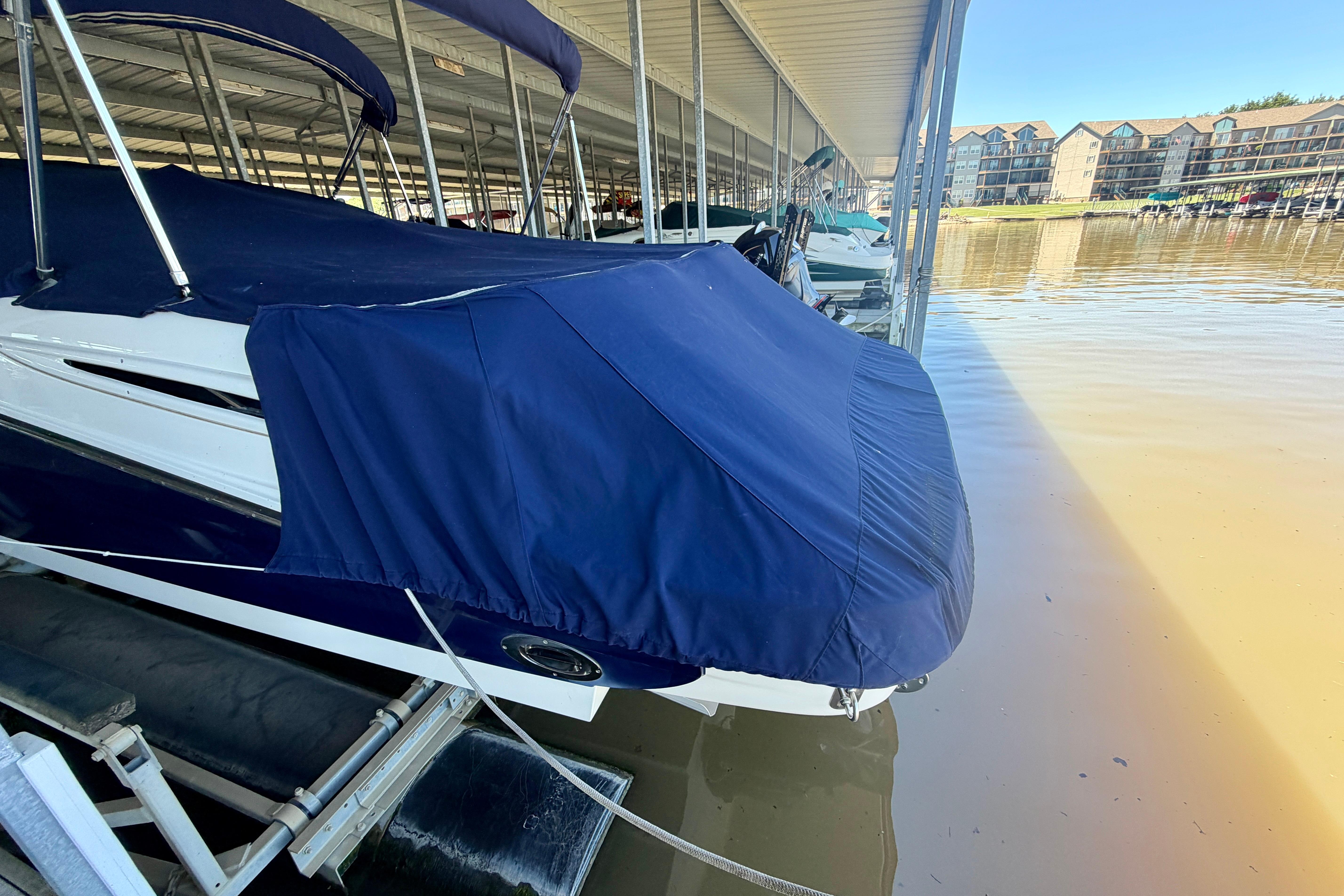 Covered 2007 Sea Ray 270 SLX boat docked in a marina under a canopy.