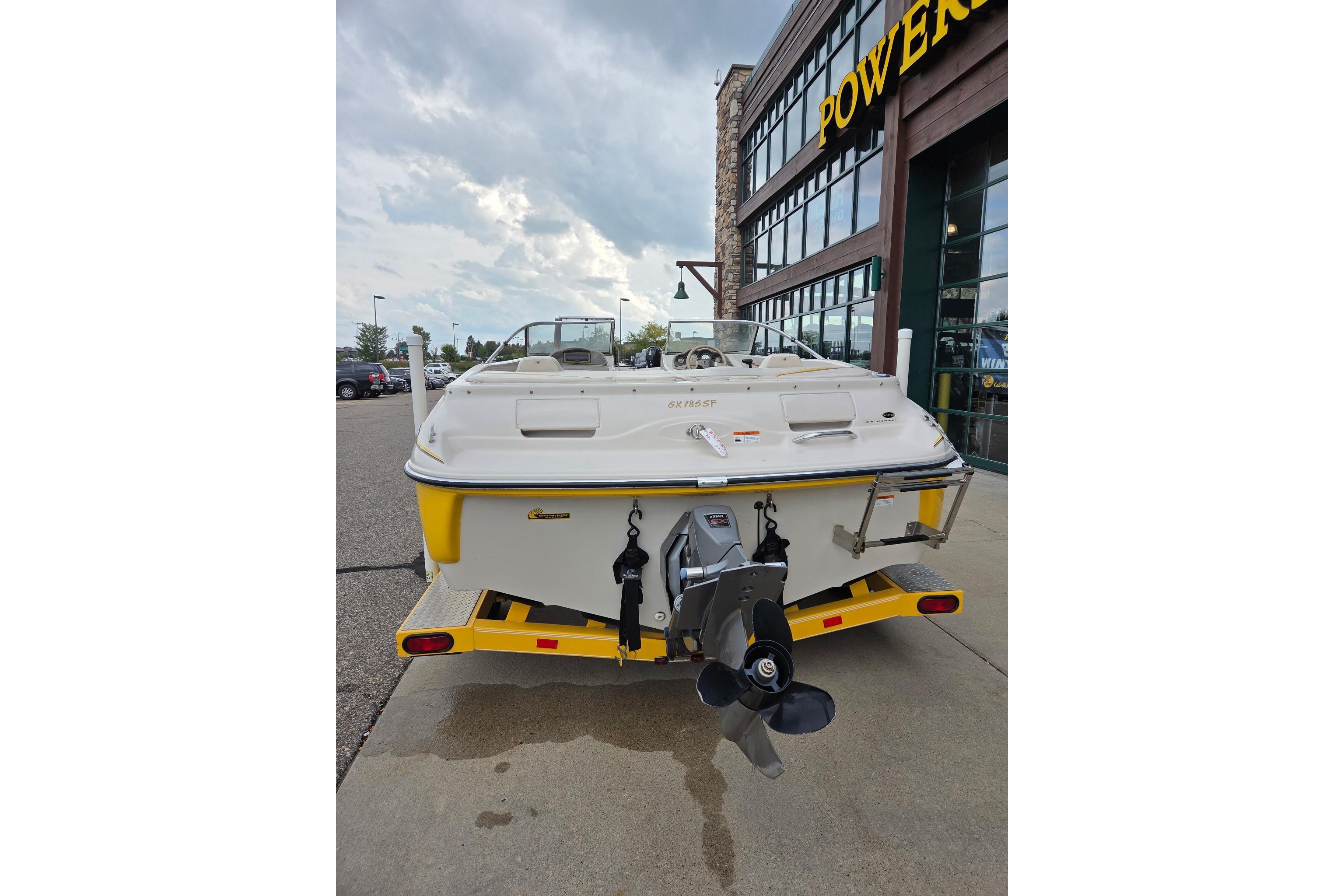 2003 Glastron GX185SF boat on trailer, parked outside a building.
