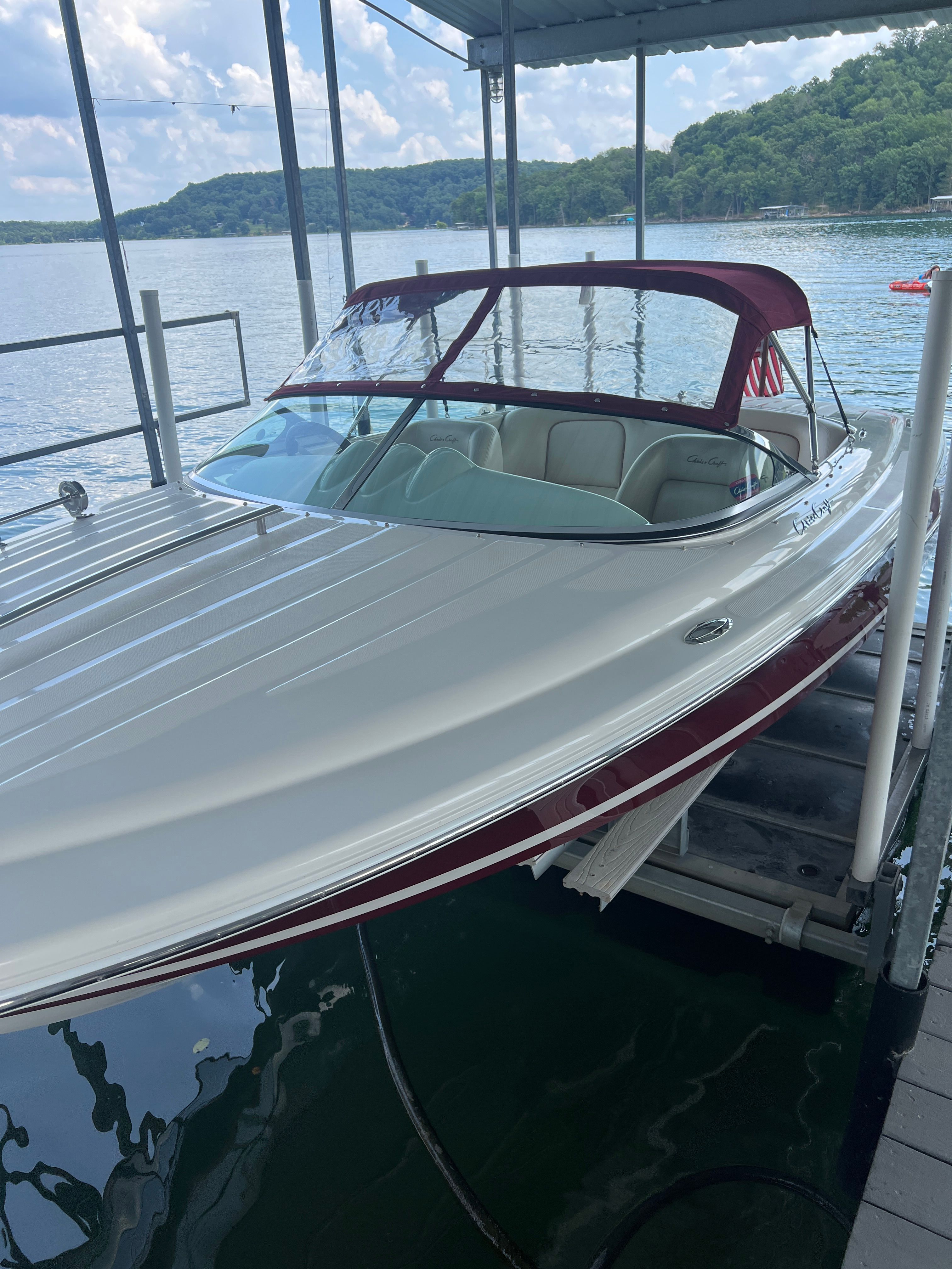 A 2006 Chris-Craft Speedster 20 docked, featuring a red canopy.