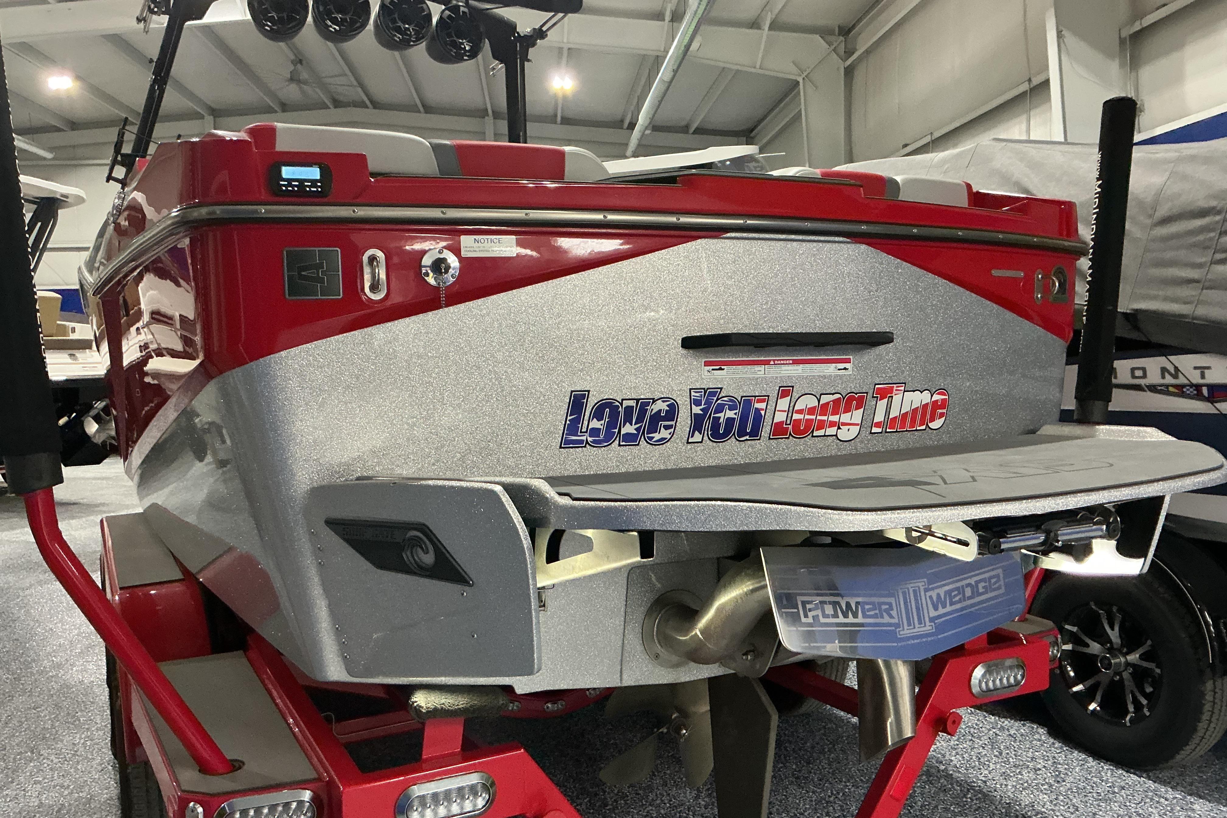 Red and silver 2022 Axis T250 boat with "Love You Long Time" text on the back.